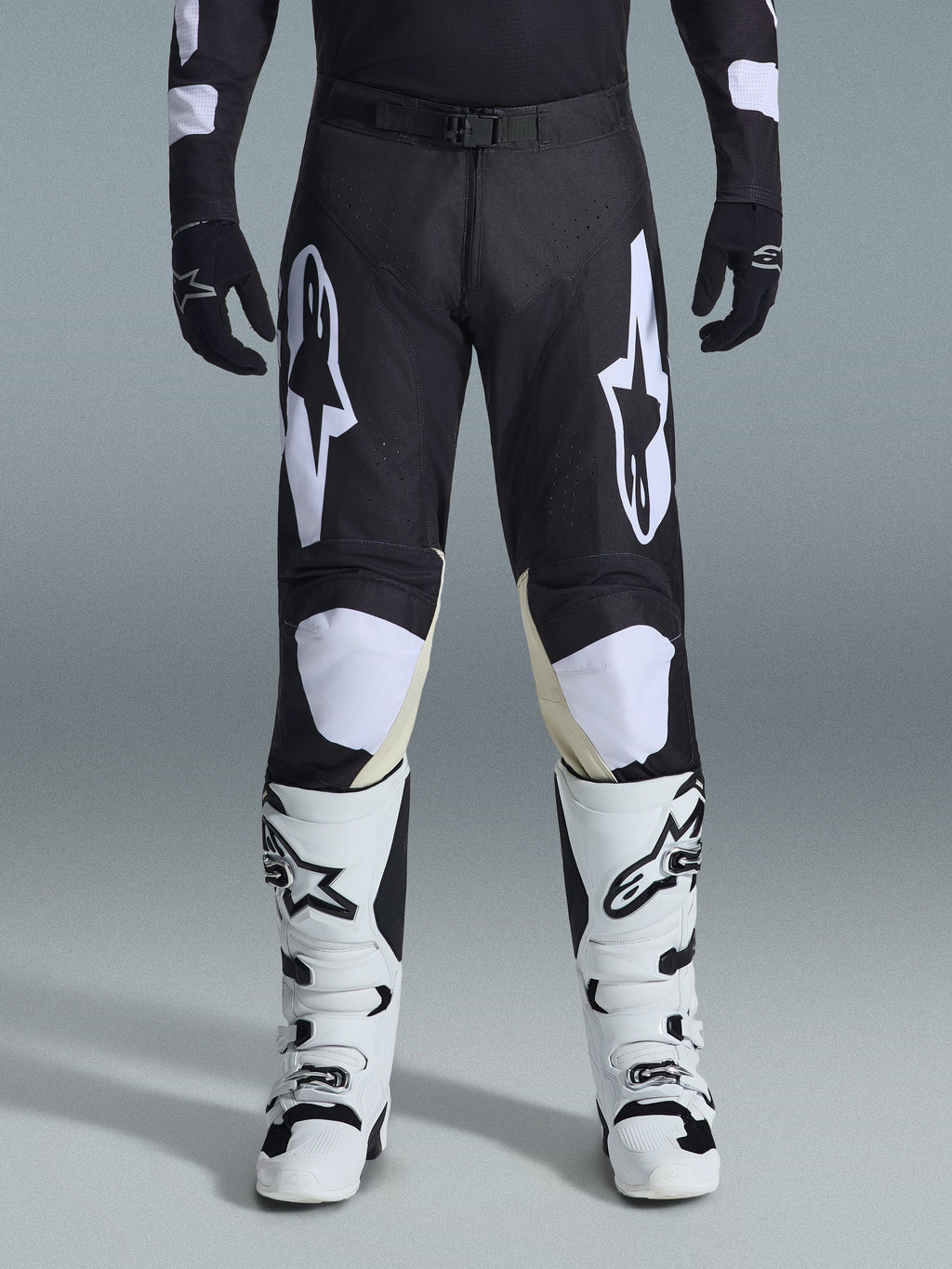 Alpinestars 2026 Racer Air Riway bukser, motocross-bukser, sort og hvid, med markante hvide Alpinestars-logoer på lårene og knæpanelerne, kombineret med hvide og sorte motocross-støvler og sorte handsker, atletisk race-fit design til off-road kørsel