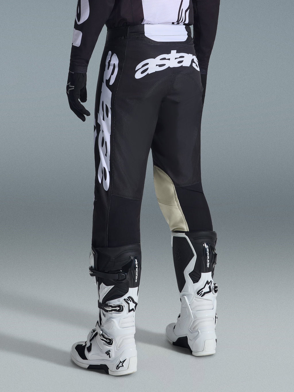 Alpinestars 2026 Racer Air Riway bukser, motocrossbukser, sort og hvid, set bagfra med stort hvidt Astars-branding på sædet og benene, beige læderpaneler på indersiden af knæene, båret med hvide og sorte Tech 7-støvler, førsteklasses off-road racingbeklædning.