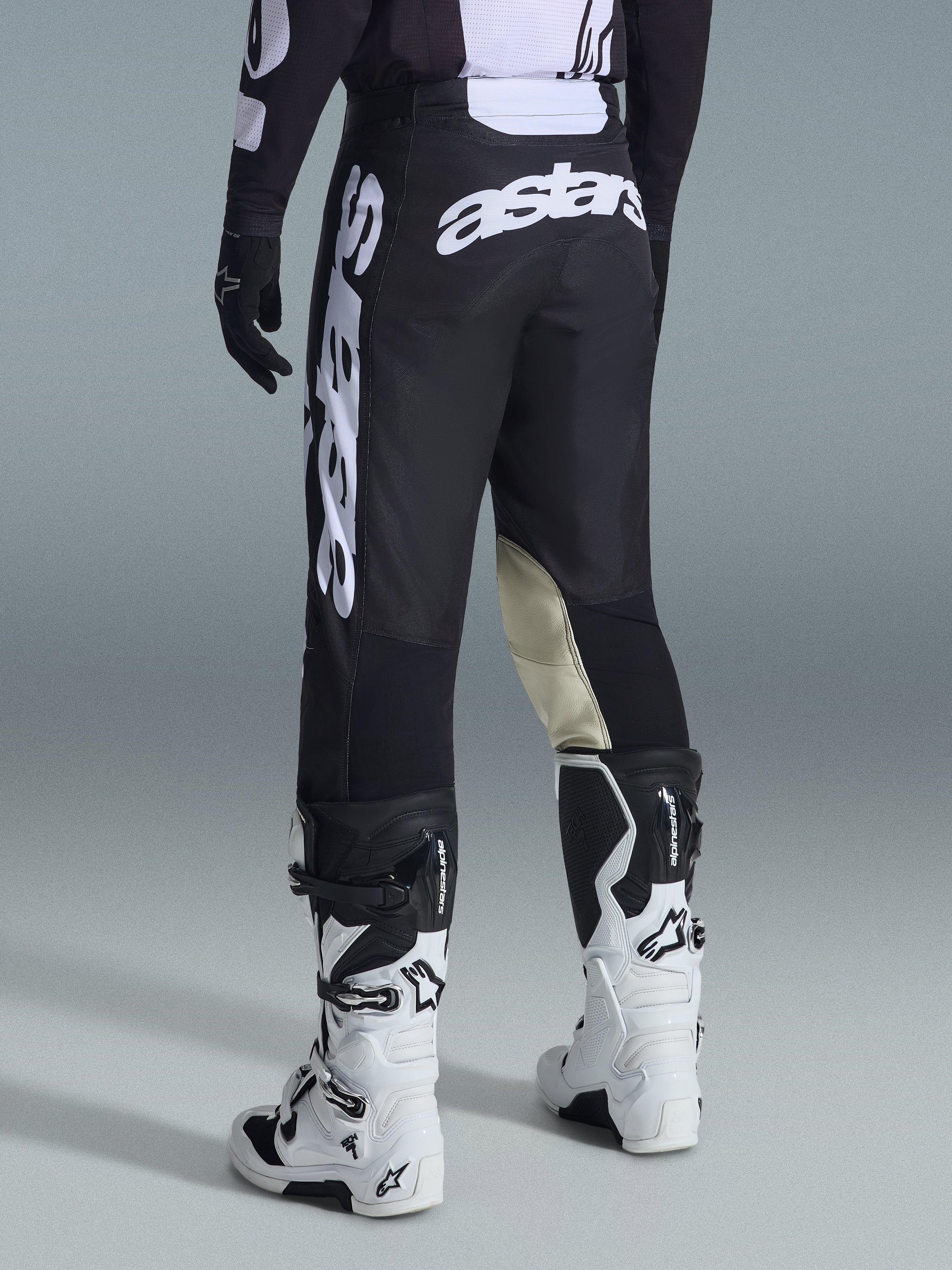 Alpinestars 2026 Racer Air Riway bukser, motocrossbukser, sort og hvid, set bagfra med stort hvidt Astars-branding på sædet og benene, beige læderpaneler på indersiden af knæene, båret med hvide og sorte Tech 7-støvler, førsteklasses off-road racingbeklædning.
