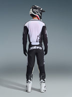 Alpinestars 2026 Racer Air Riway bukser, set bagfra, sort og hvid, matchende sort og hvid langærmet jersey, hvide og sorte racingstøvler og sort hjelm med Alpinestars-branding, motocross-udstyr