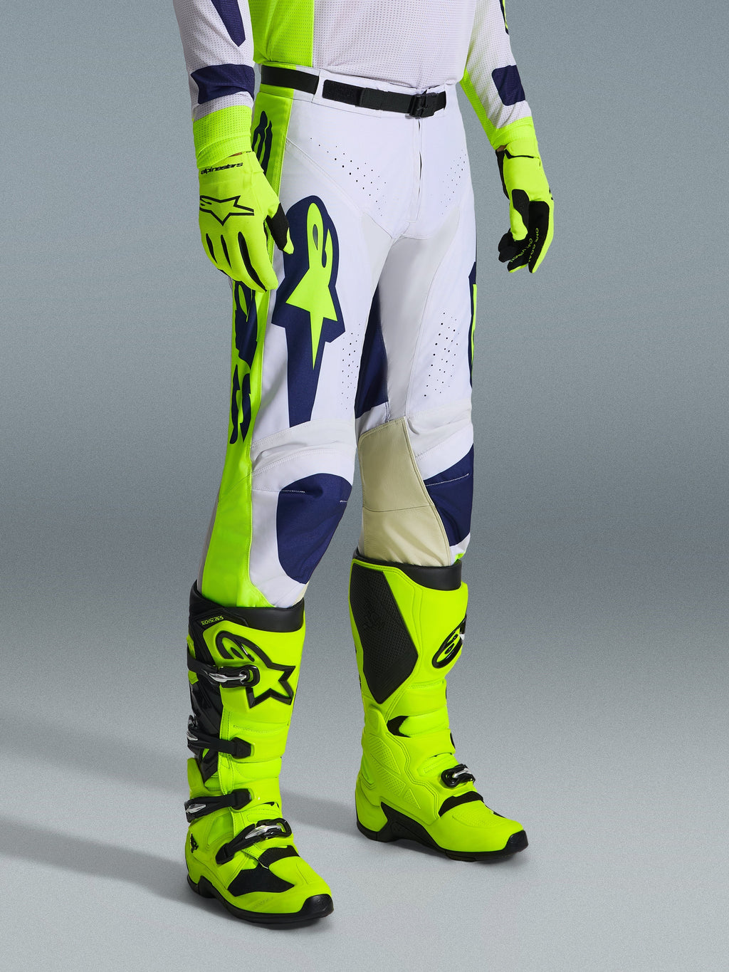 Alpinestars 2026 Racer Air Riway bukser, motocrossbukser, lysegrå, gul fluo og blå, båret med matchende gul fluo handsker og støvler, stort blåt logo på låret, perforerede ventilationspaneler, holdbart udstyr til motocross