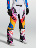 Alpinestars Supertech Dyna Pants in white and blithe blue, premium motocross racing pants on-model with stretch rip-stop fabric and goat leather knee panels.