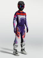Alpinestars Supertech Dyna bukser i lilla og pink fluo, herre-motocrossudstyr med matchende trøje og hvide racingstøvler.