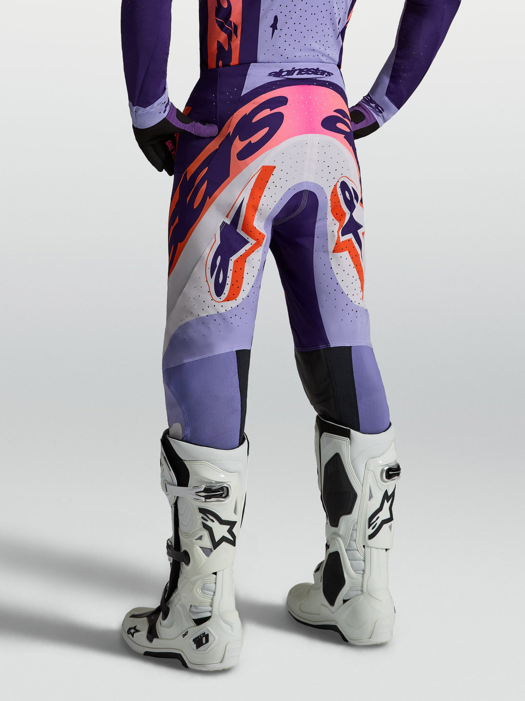 Alpinestars Supertech Dyna bukser, lilla og pink motocrossbukser til herre, åndbart ripstop, set bagfra med hvide støvler.