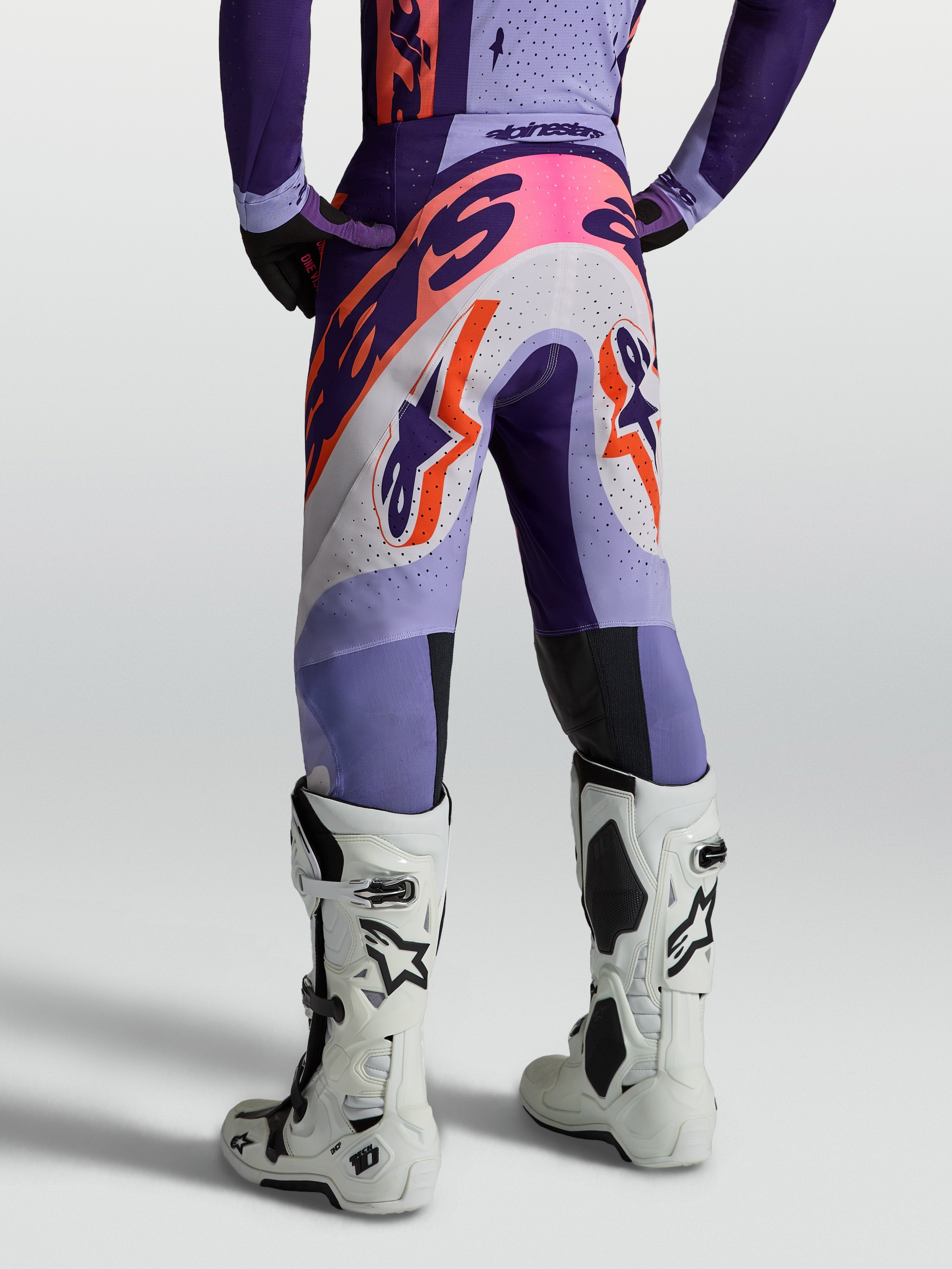 Alpinestars Supertech Dyna bukser, lilla og pink motocrossbukser til herre, åndbart ripstop, set bagfra med hvide støvler.