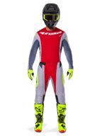 Motocross-rytter iført Alpinestars 2025 Techstar Melt-udstyrssæt i Bright Red Gray, med en rød jersey med grå ærmer, grå bukser med røde og neongule detaljer, matchende neongule støvler og handsker samt en sort hjelm med neongule briller.