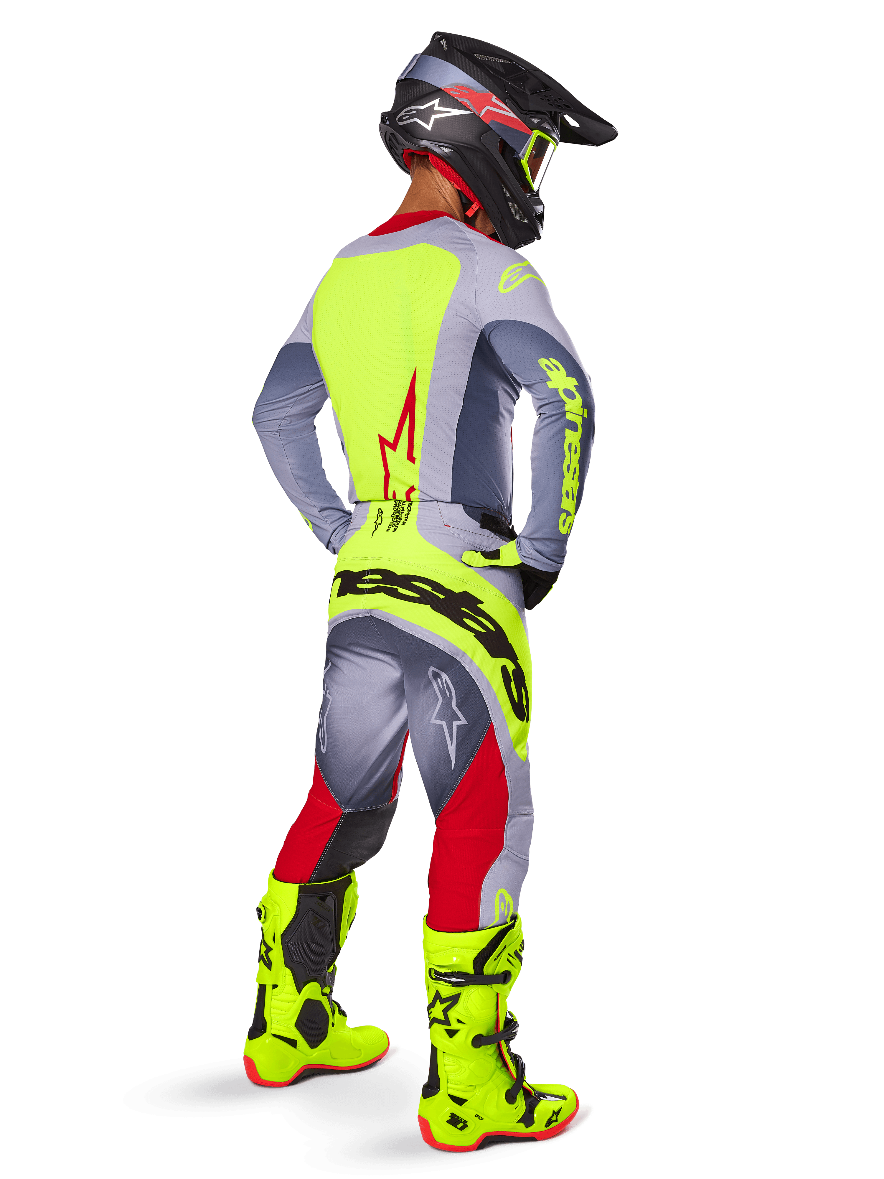 Motocross rider from a rear three-quarter view wearing Alpinestars 2025 Techstar Melt Pants in Bright Red and Gray, featuring a bold neon yellow logo across the seat, matching gray and neon yellow jersey, bright neon yellow boots, and a black helmet with neon goggles, professional off-road racing gear set.