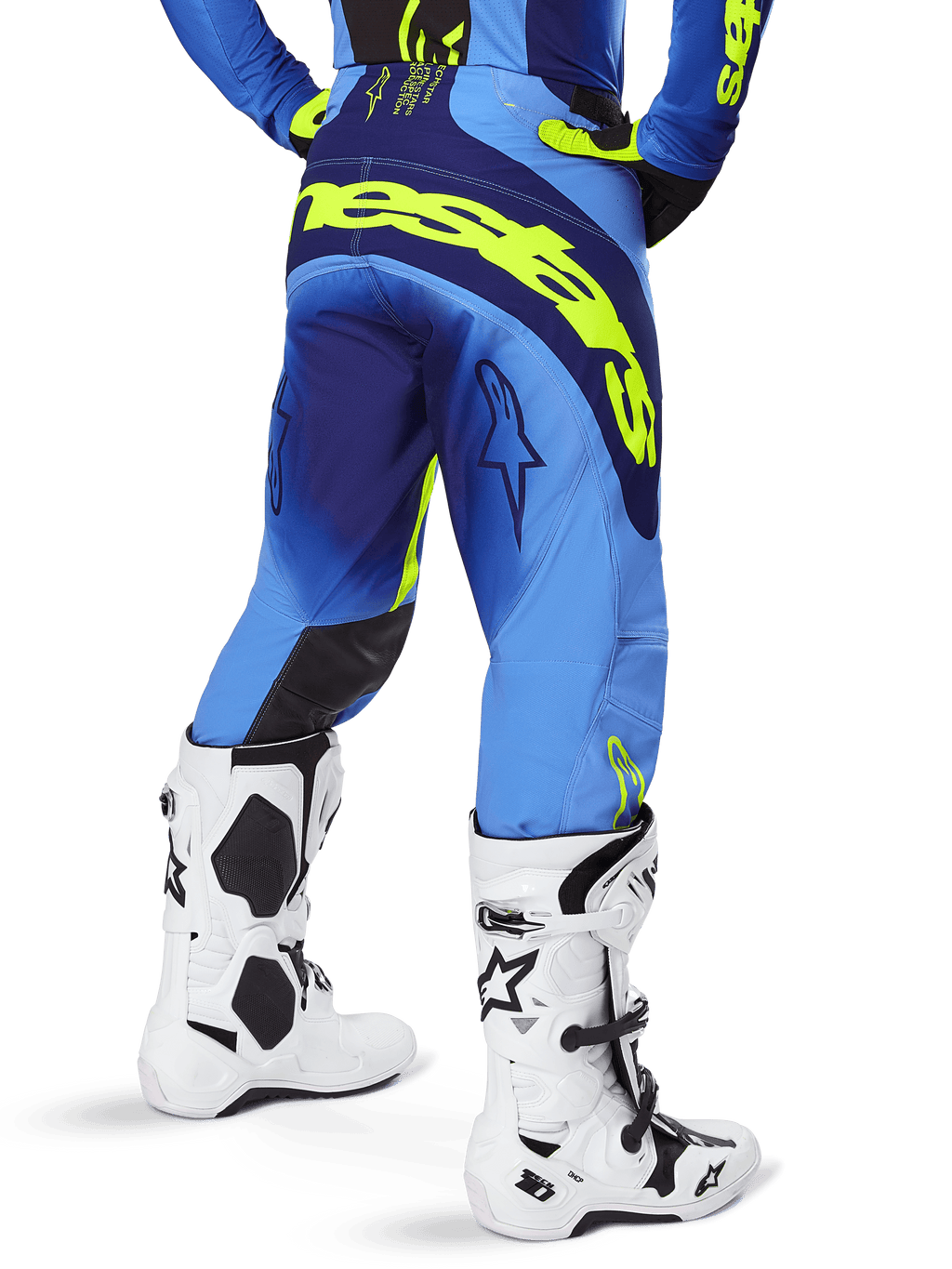 Alpinestars 2025 Techstar Melt bukser, motocrossbukser, blå og gul fluo, set bagfra med stort gult logo på sædet og lårene, bæres med hvide motocrossstøvler og matchende blå trøje, atletisk race-pasform til terrænkørsel