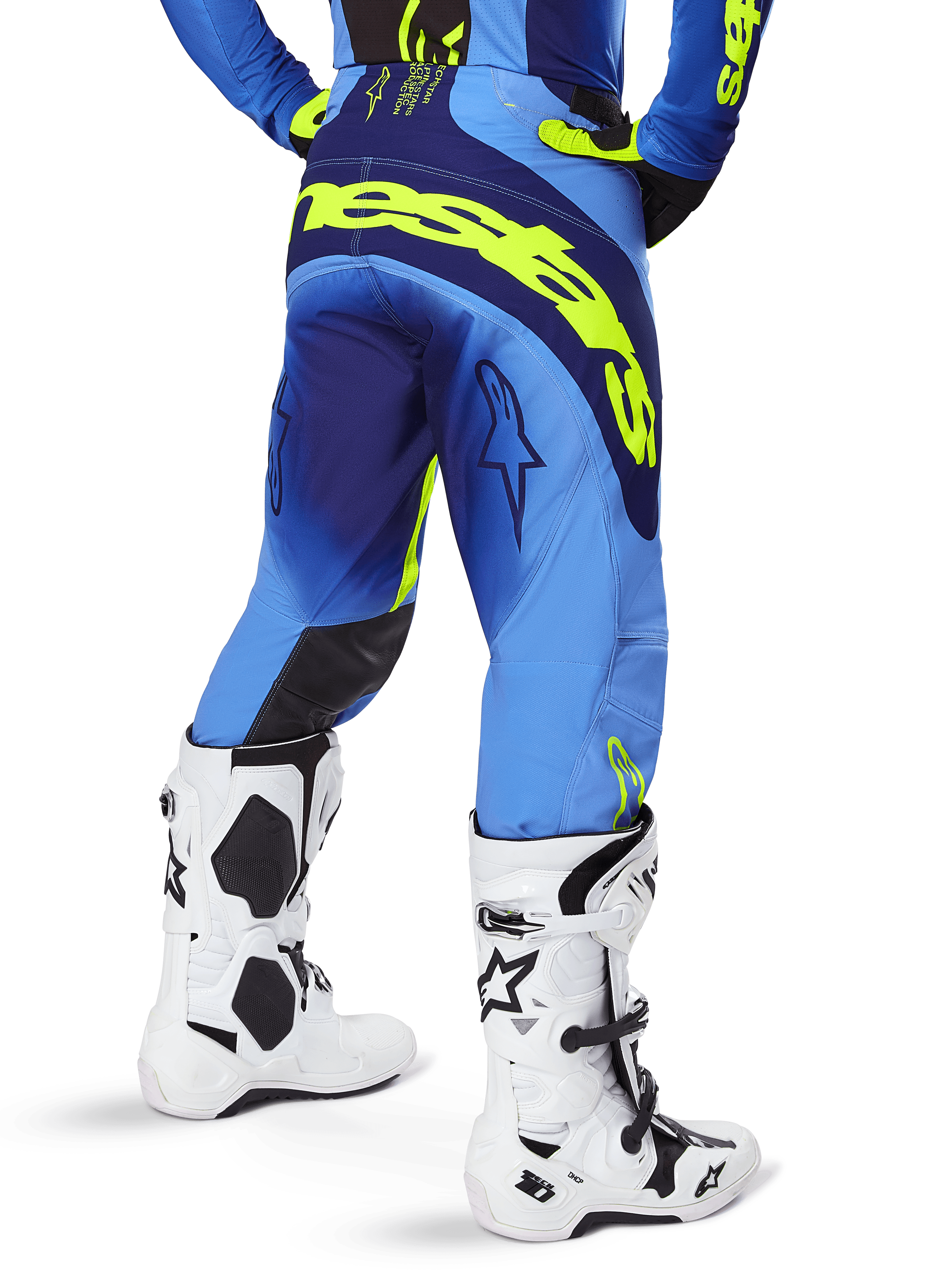 Alpinestars 2025 Techstar Melt bukser, motocrossbukser, blå og gul fluo, set bagfra med stort gult logo på sædet og lårene, bæres med hvide motocrossstøvler og matchende blå trøje, atletisk race-pasform til terrænkørsel