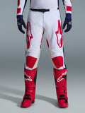 Alpinestars 2026 Racer Riway bukser, motocross-bukser, hvid, blå og rød, båret med røde støvler og mørkeblå handsker, med store røde logoer på lårene og røde knæpaneler, sportsligt forbuet design med justerbart taljespænde
