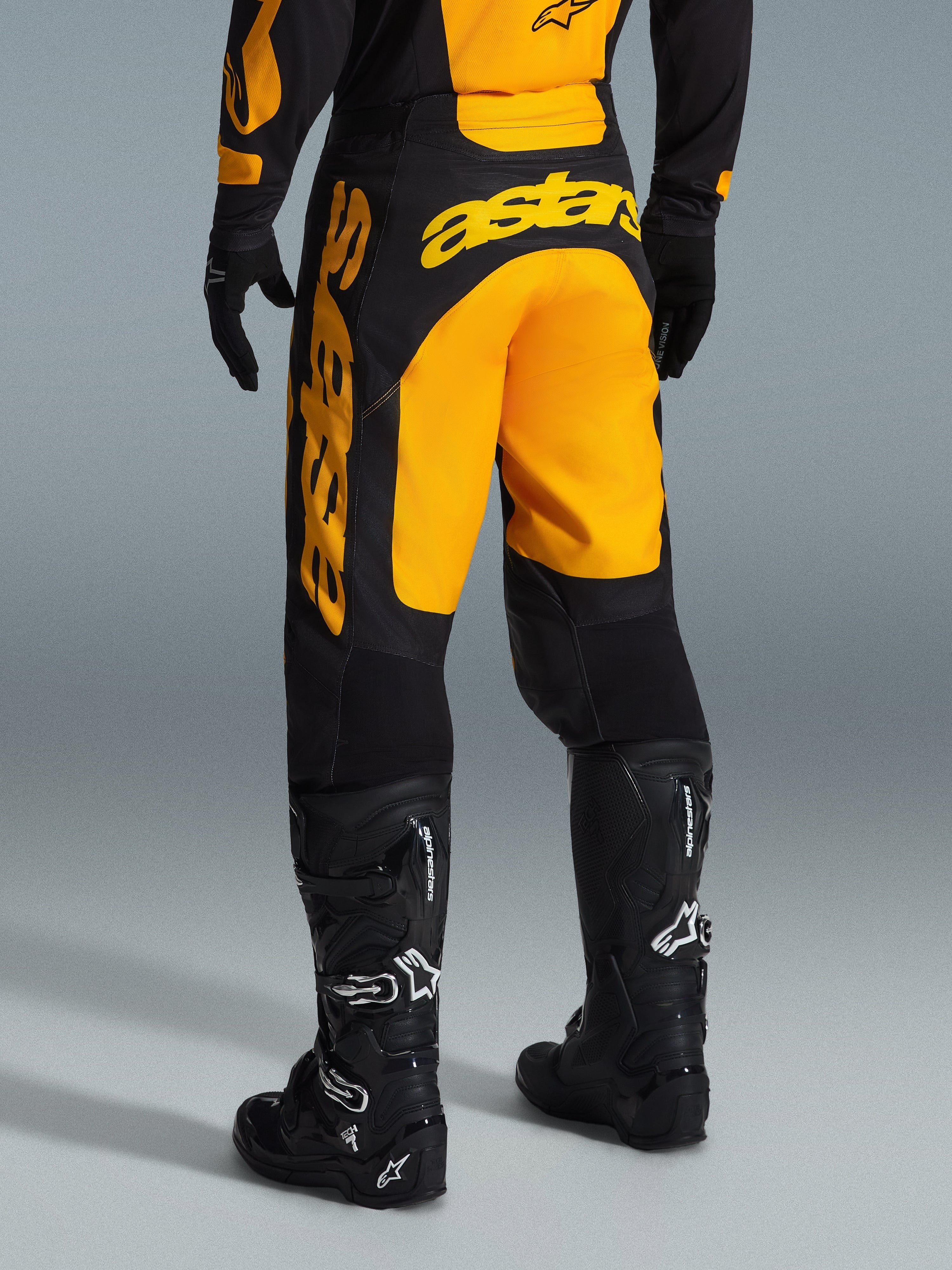 Alpinestars 2026 Racer Riway bukser, motocrossbukser, gul og sort, set bagfra med markant gult astars-branding over sædet og benet, kombineret med sorte motocross-støvler og handsker