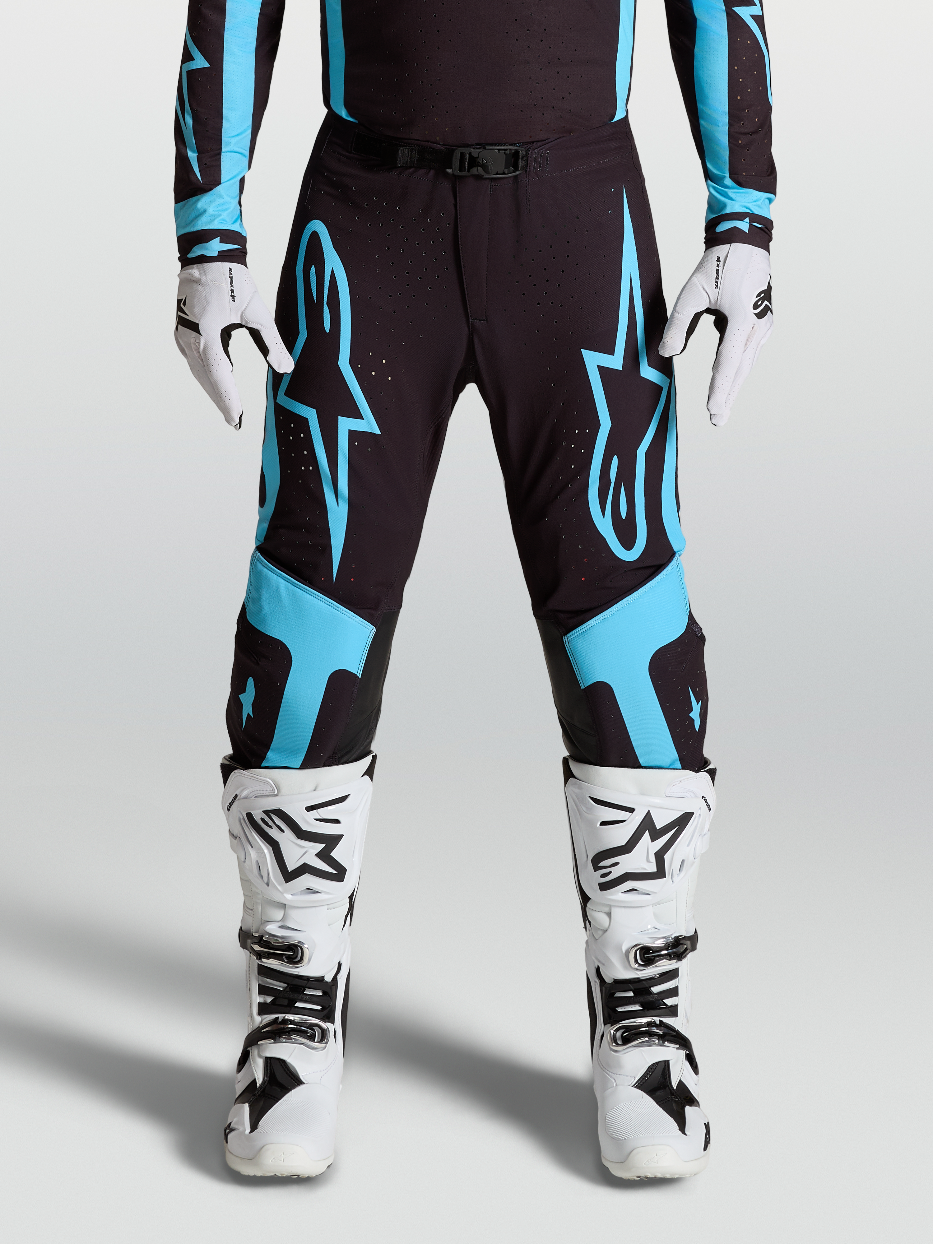 Alpinestars Supertech Vesta Pants, pro motocross racing gear, Black and Turquoise with large star graphics and leather knee panels.