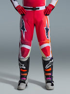 Alpinestars 2026 Racer Portl bukser, motocrossbukser, rød, lysegrå og mørkegrå, båret med matchende røde handsker og flerfarvede støvler, med markante Alpinestars-stjernelogoer på lårene og hvide detaljer, sporty design til off-road racing