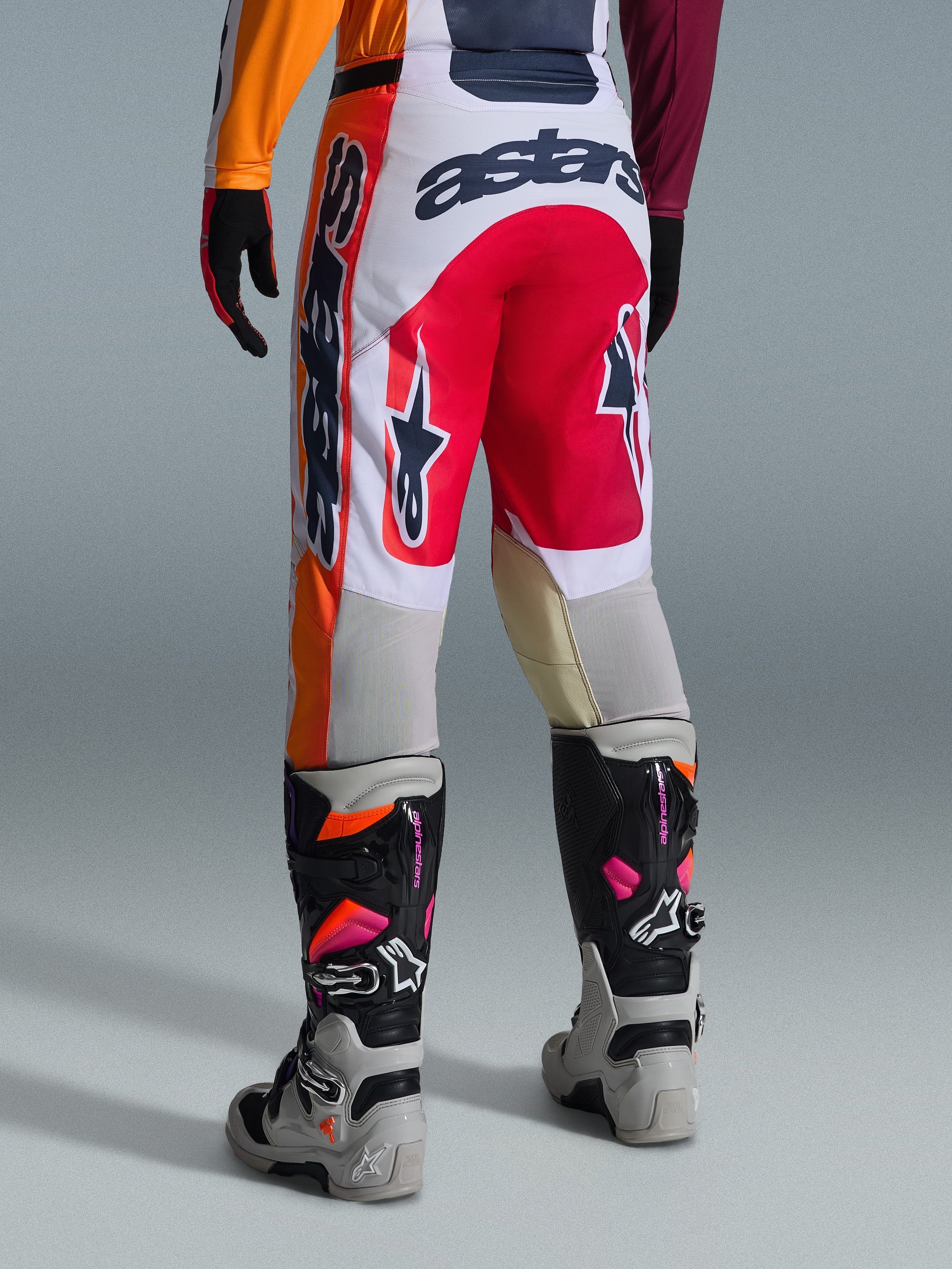 Alpinestars 2026 Racer Portl bukser, motocross-bukser, rød, lysegrå og mørkegrå, set bagfra med markant branding og logodetaljer, kombineret med matchende motocross-støvler og handsker, præstationsudstyr til off-road racing.