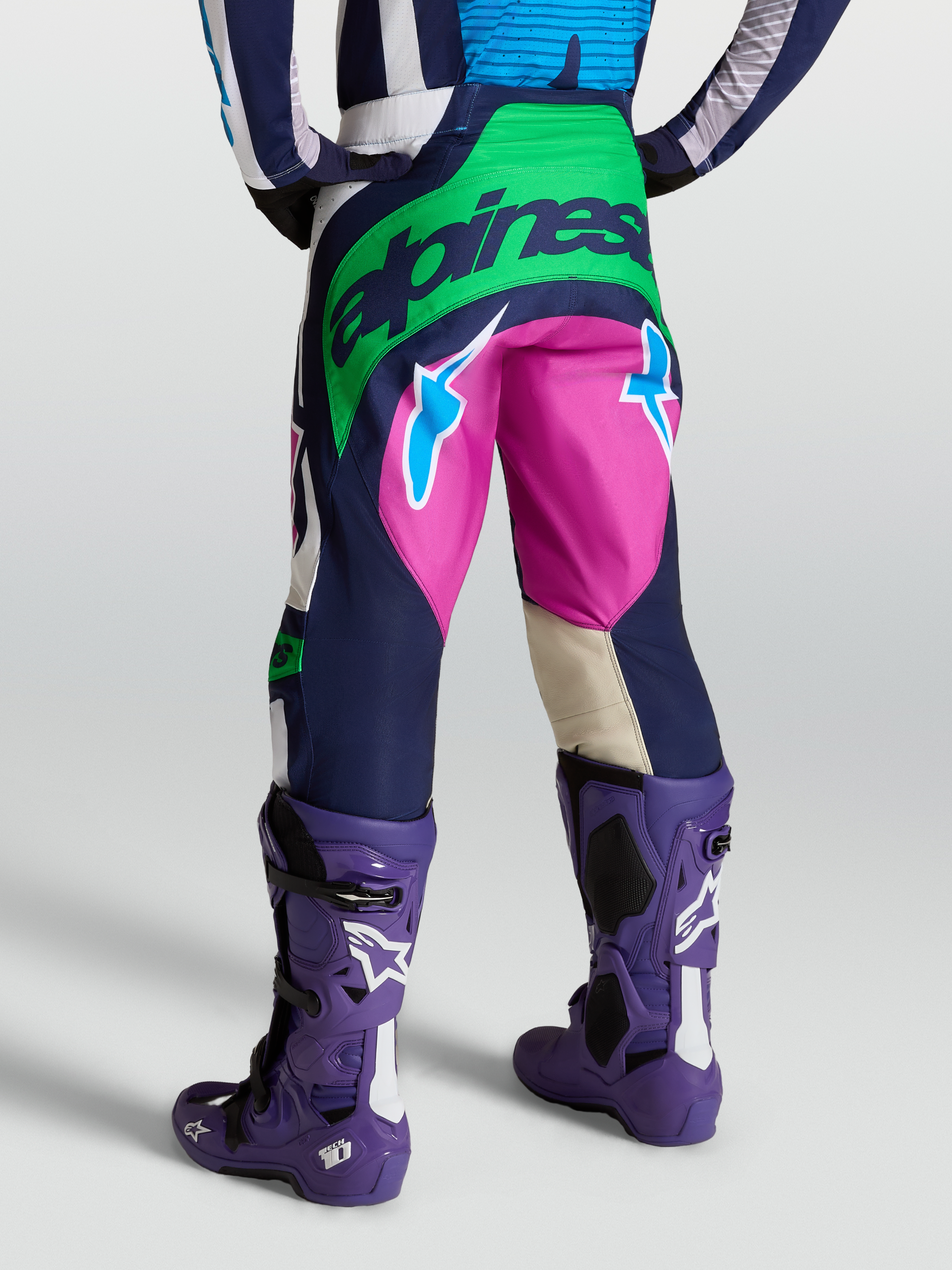 Alpinestars Techstar Maven Pants, Blue and Green motocross gear, rear view on model with Tech 10 boots.