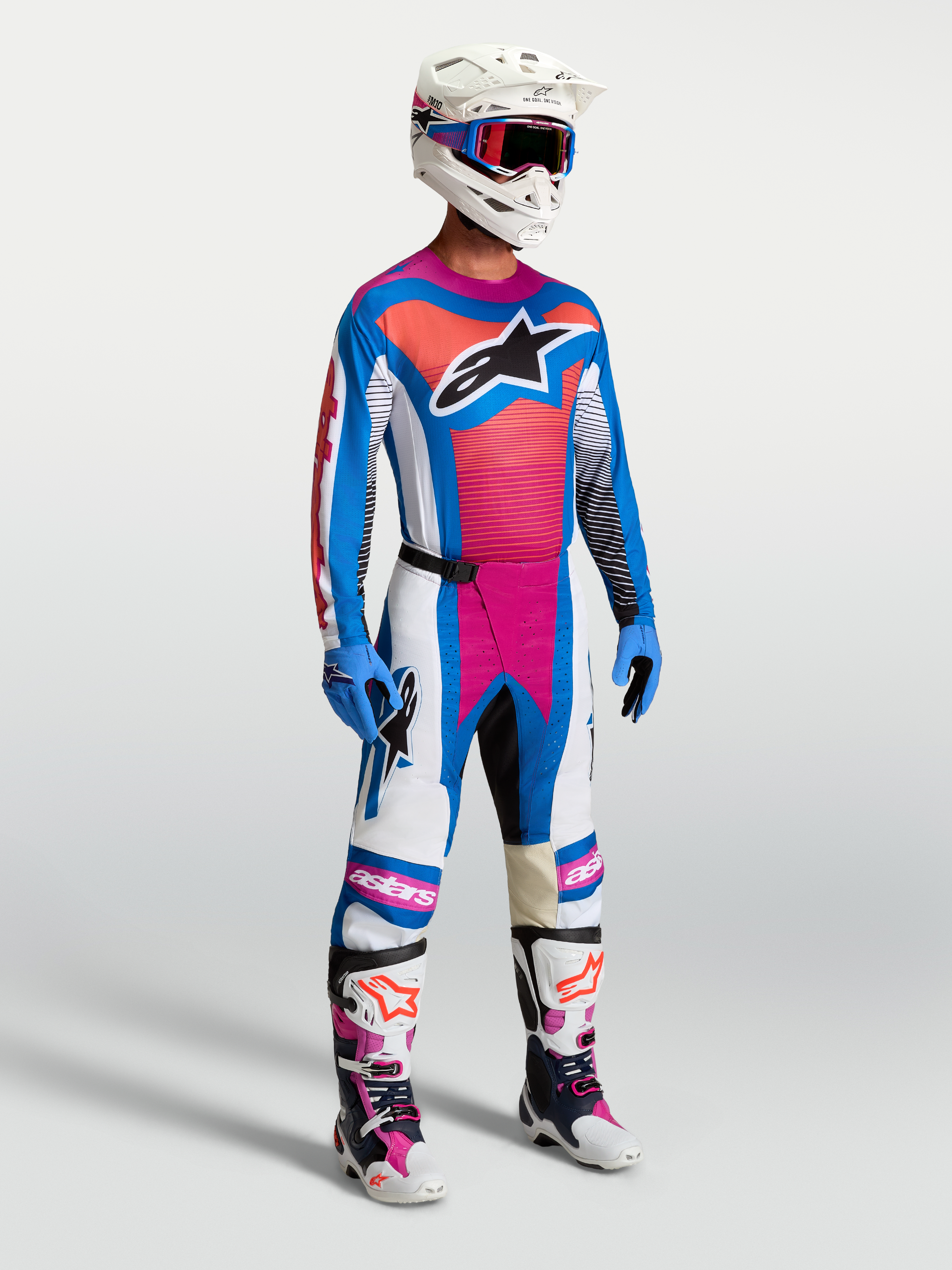 Alpinestars Techstar Maven Pants in White, Hot Coral, and Blue, shown on-model as part of a complete motocross racing gear set.