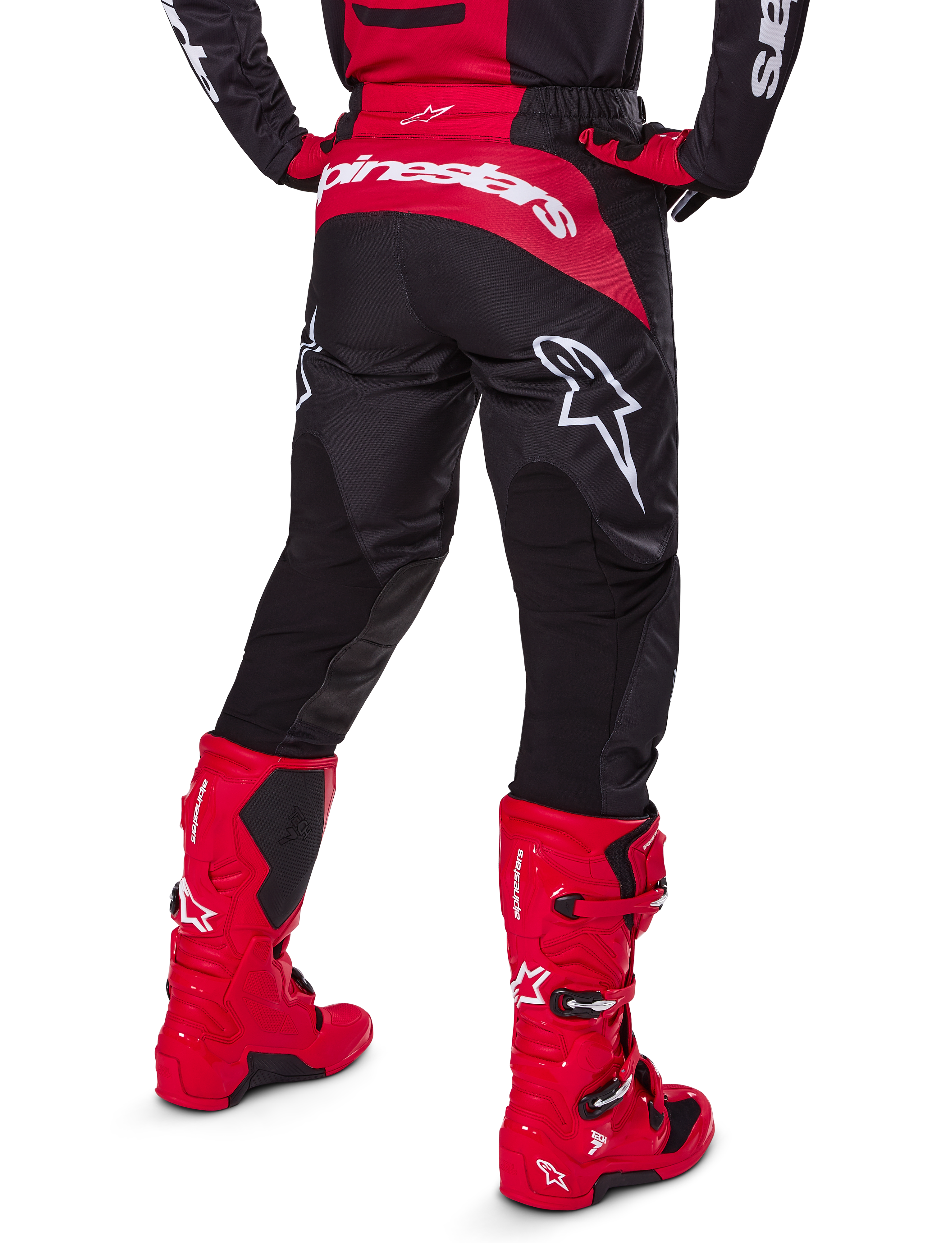 Alpinestars 2025 Fluid Haul-udstyrssæt, set bagfra, sorte og røde motocrossbukser med store hvide logoer, matchende trøje og røde Tech 7-støvler, koordineret off-road racingudstyr