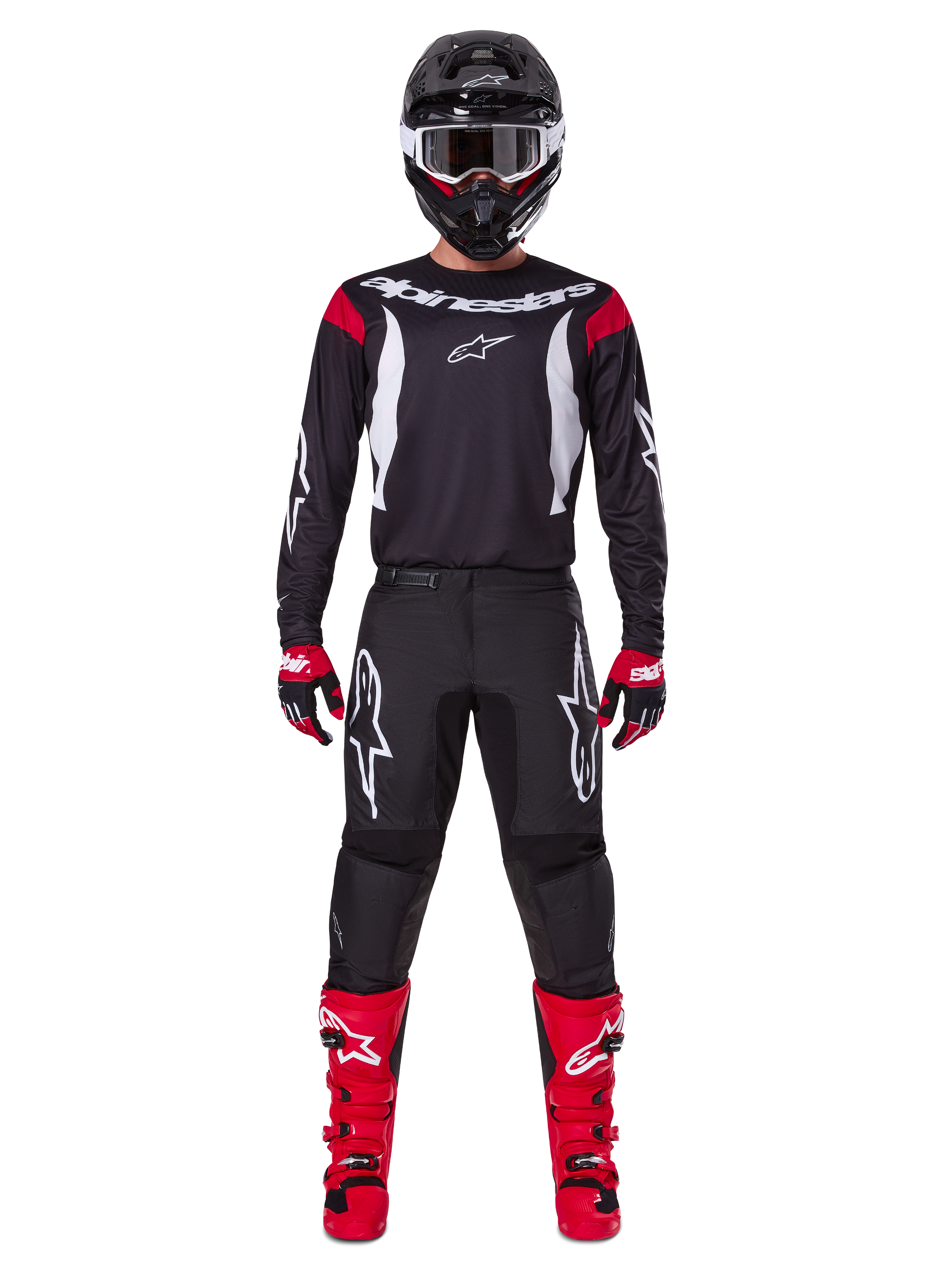 Alpinestars 2025 Fluid Haul Gear Set, Motocross rider in full racing gear, black jersey with red shoulder accents and white logos, black pants with white star branding, bright red boots, red and black gloves, black helmet with white goggles, coordinated off-road performance look