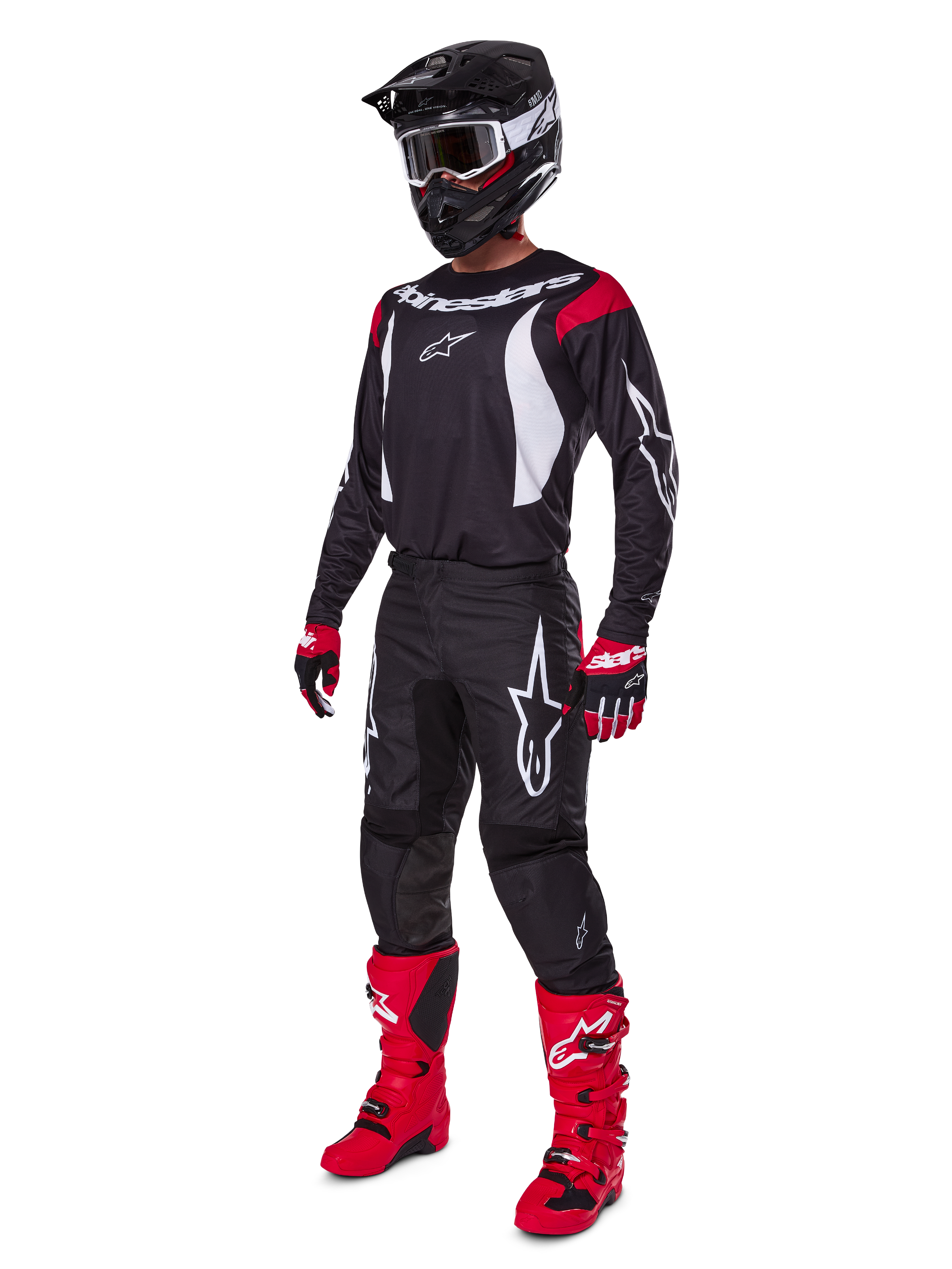 Motocross-kører iført komplet Alpinestars 2025 Fluid Haul-udstyrssæt, sort trøje med røde og hvide detaljer, sorte bukser med hvide logoer, stærkt røde støvler, røde og sorte handsker, sort hjelm med goggles, koordineret off-road-performanceudstyr