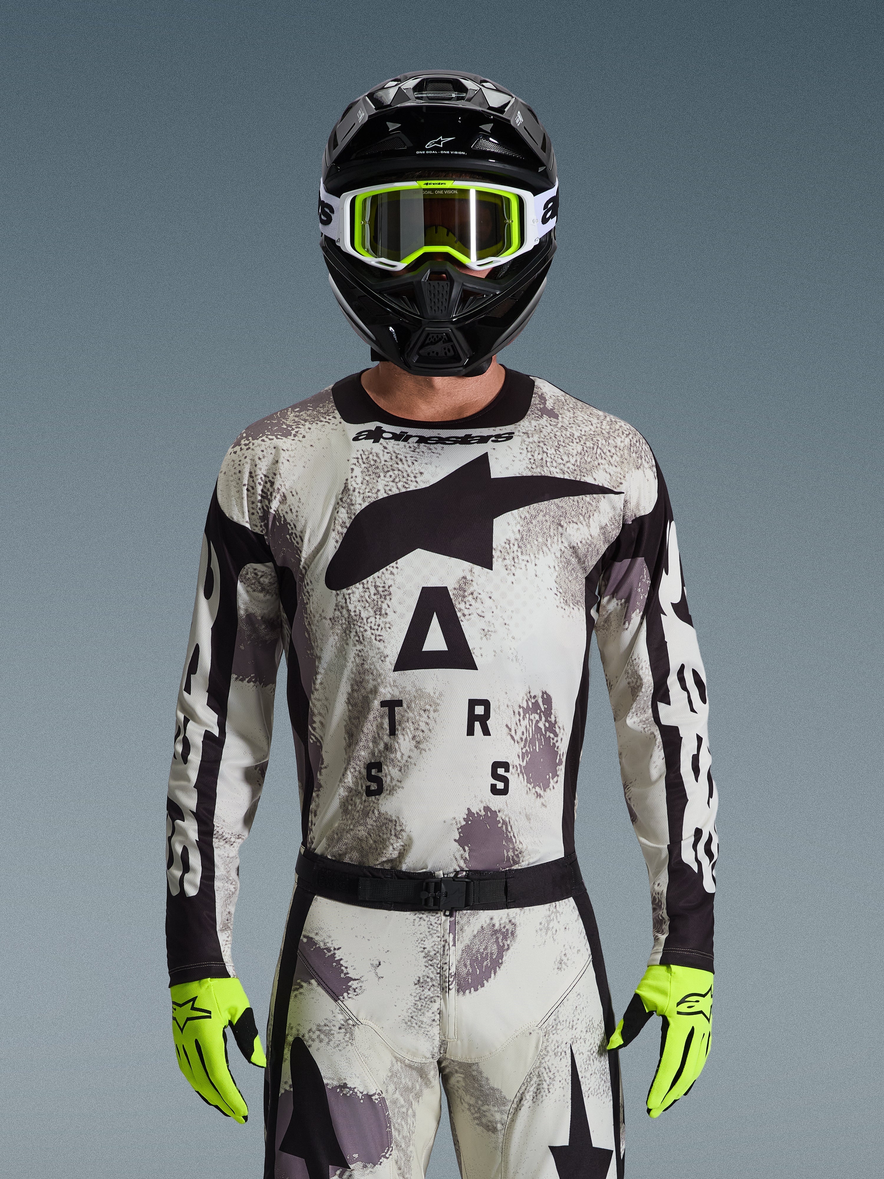 Alpinestars 2026 Racer Lahnd Jersey, motocross-udstyrssæt, Sand Camo-mønster i grå og hvid, stort sort stjernelogo og 'ASTARS'-tekst, båret med sort hjelm, neongule goggles og neongule handsker, professionelt terrænkørselsudstyr