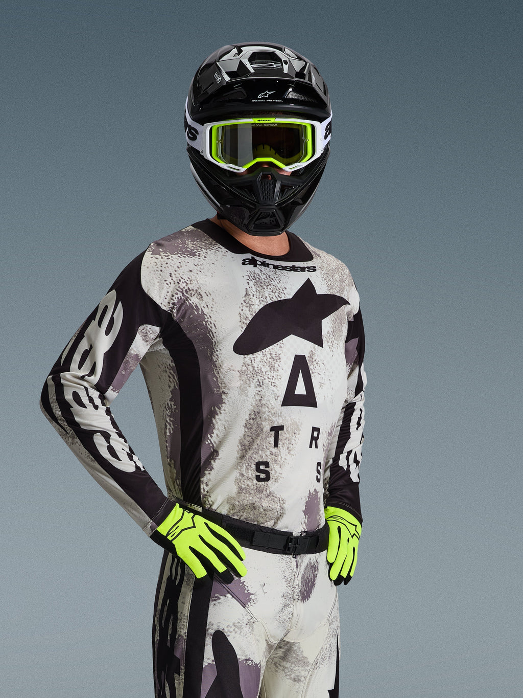 Alpinestars 2026 Racer Lahnd trøje, motocross-trøje, Sand Camo med gråt og sort mønster, stort Astars-logo på brystet, båret med sort hjelm, neongule briller og handsker, performance off-road racingudstyr