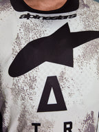Alpinestars 2026 Racer Lahnd trøje, motocross-trøje, hvidt og gråt nistret mønster, nærbillede af brystet med stort sort Astars-logo og Alpinestars-branding ved halsudskæringen, præstationsorienteret design til off-road kørsel