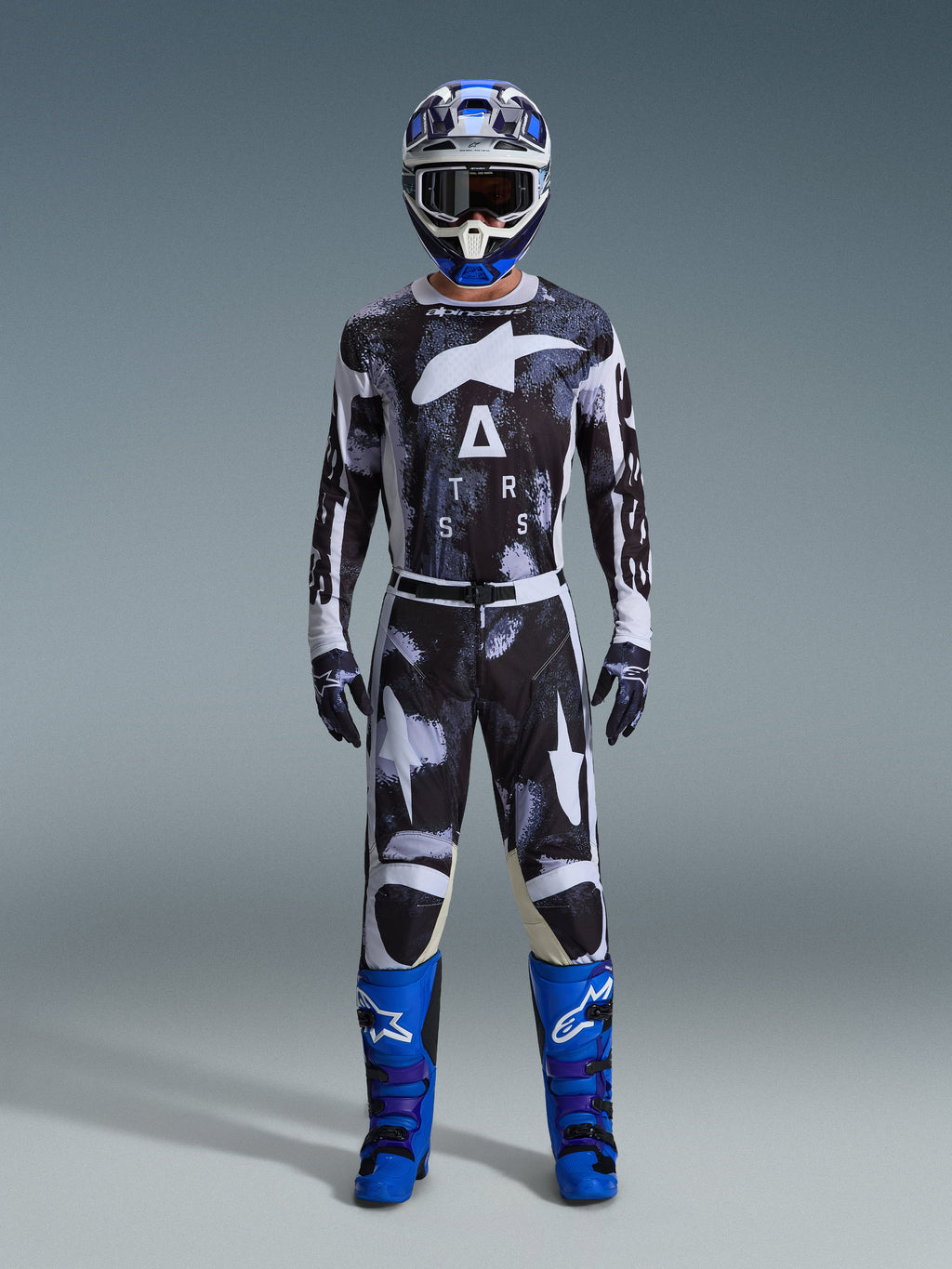 Alpinestars 2026 Racer Lahnd udstyrssæt, motocross-outfit, sort og hvid med abstrakt Iron Camo-mønster, kombineret med blå og hvid hjelm og pangblå støvler, komplet racersæt til off-road performance