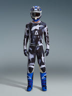 Alpinestars 2026 Racer Lahnd udstyrssæt, motocross-outfit, sort og hvid med abstrakt Iron Camo-mønster, kombineret med blå og hvid hjelm og pangblå støvler, komplet racersæt til off-road performance