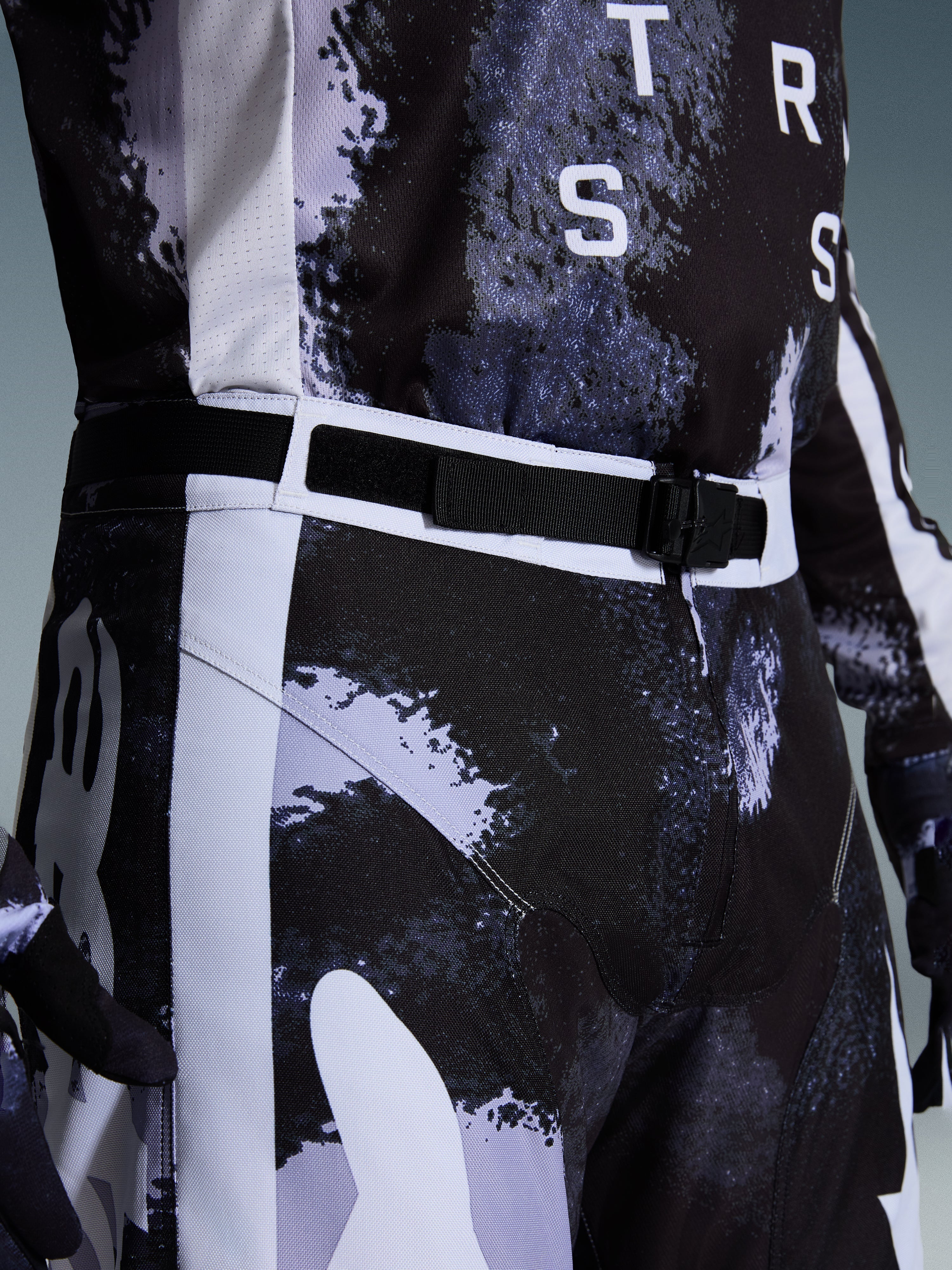 Alpinestars 2026 Racer Lahnd bukser, motocrossbukser i Iron Camo, nærbillede af det justerbare taljebælte og SX2 magnetiske spænde, gråt og sort camouflage-mønster, holdbar 600D polyfabric-konstruktion