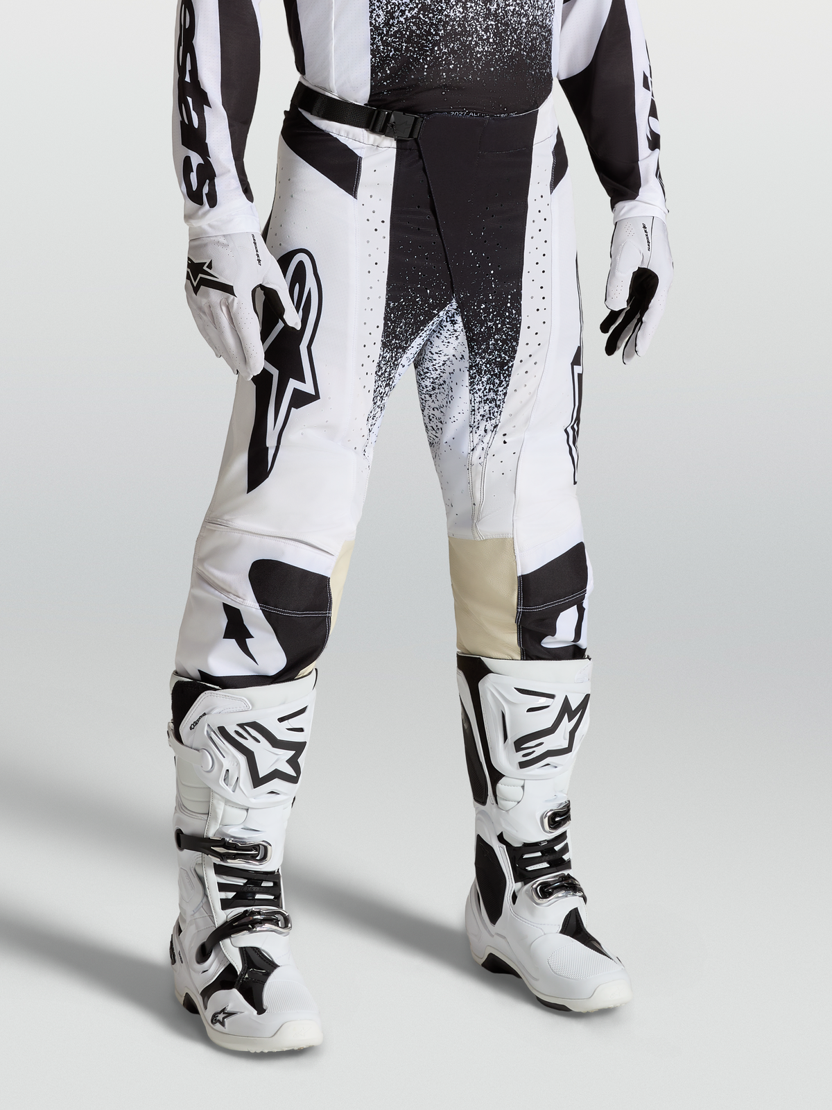 Alpinestars Techstar Swan Bukser, motocrossbukser i race-fit, hvid og sort, strækbar ripstop-konstruktion, vist på model med matchende hvide støvler