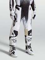 Alpinestars Techstar Swan Bukser, motocrossbukser i race-fit, hvid og sort, strækbar ripstop-konstruktion, vist på model med matchende hvide støvler
