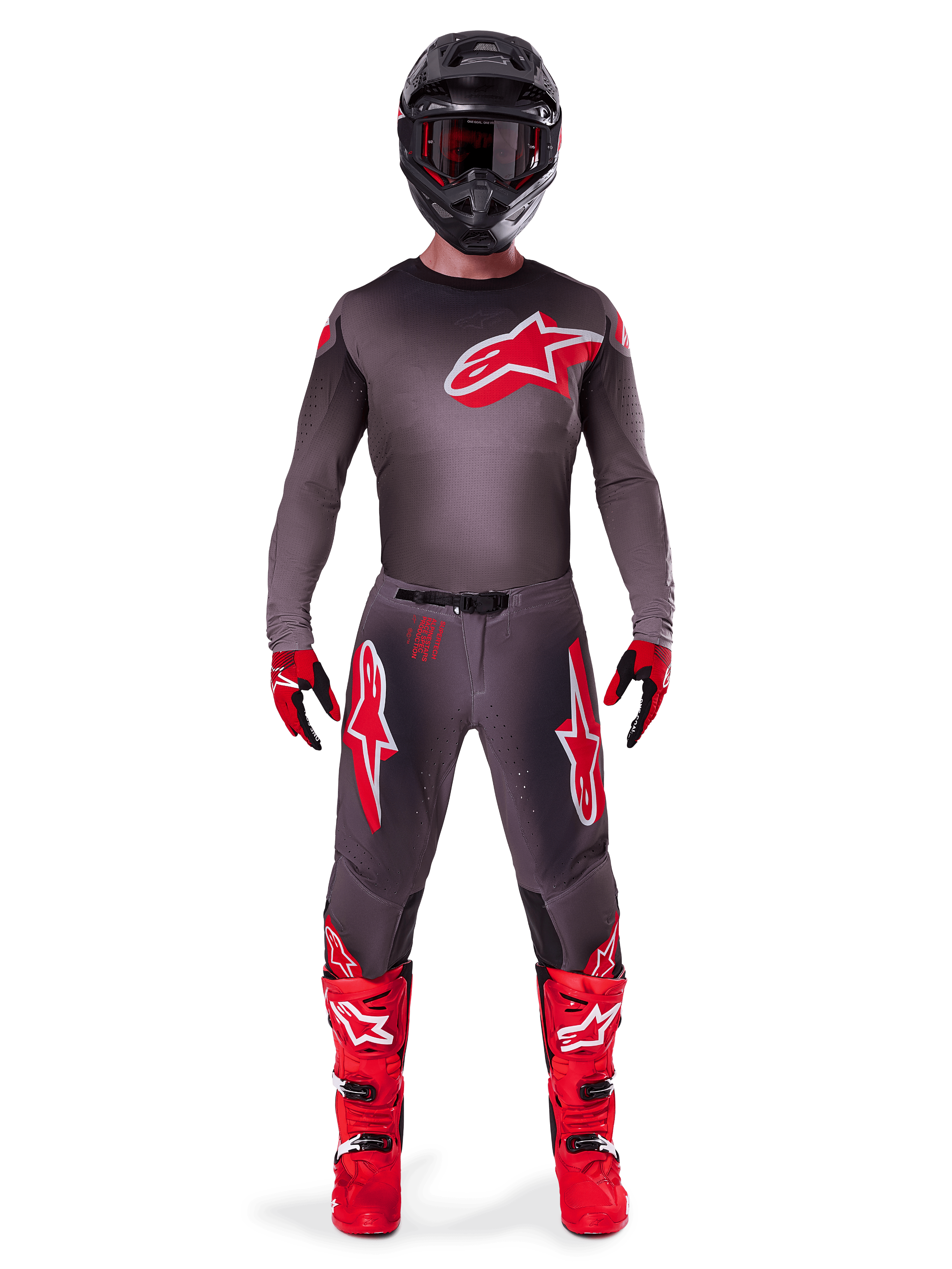 Motocross-kører iført komplet Alpinestars 2025 Supertech Lipan gear-sæt, Smoke Bright Red, med mørkegrå trøje og bukser med fremtrædende røde logoer, sort hjelm med briller, røde og sorte handsker og klare røde motocross-støvler, koordineret professionelt raceroutfit.
