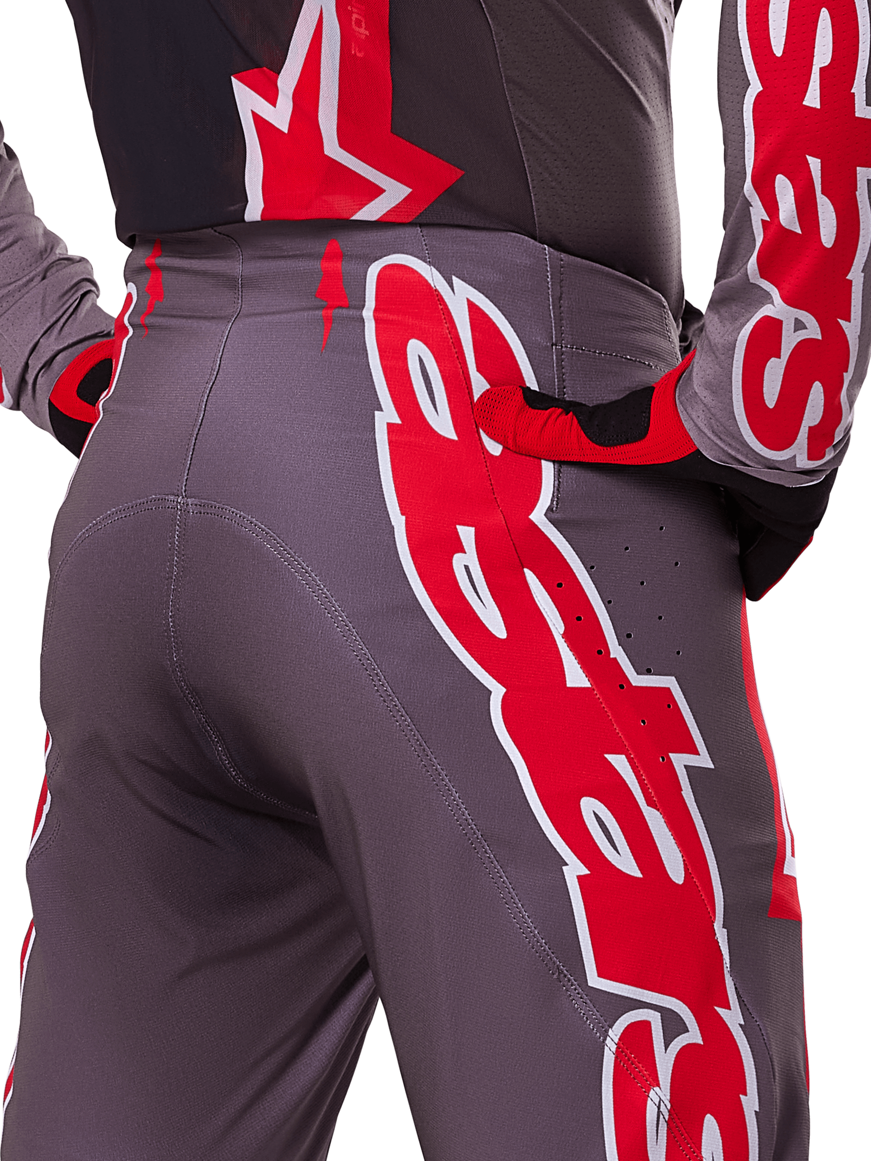 Alpinestars 2025 Supertech Lipan bukser, motocrossbukser, Smoke Bright Red og grå, nærbillede af hofte og bagside, der viser markant rød og hvid logografik, ventilationsperforeringer og atletisk race-pasform båret med matchende udstyr