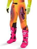 Alpinestars 2025 Supertech Lipan udstyrssæt, motocross-bukser, gul og orange farveovergang med pink og lilla detaljer, markante sorte Alpinestars-logoer på lårene, båret med gule handsker og pink motocross-støvler