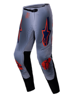 Alpinestars 2025 Supertech Lipan bukser, motocross-bukser, grå og orange fluo, med markante orange og navyblå stjerne-logoer på lår og knæ, sorte indvendige benpaneler og et justerbart taljebælte, designet til off-road ydeevne på professionelt niveau.