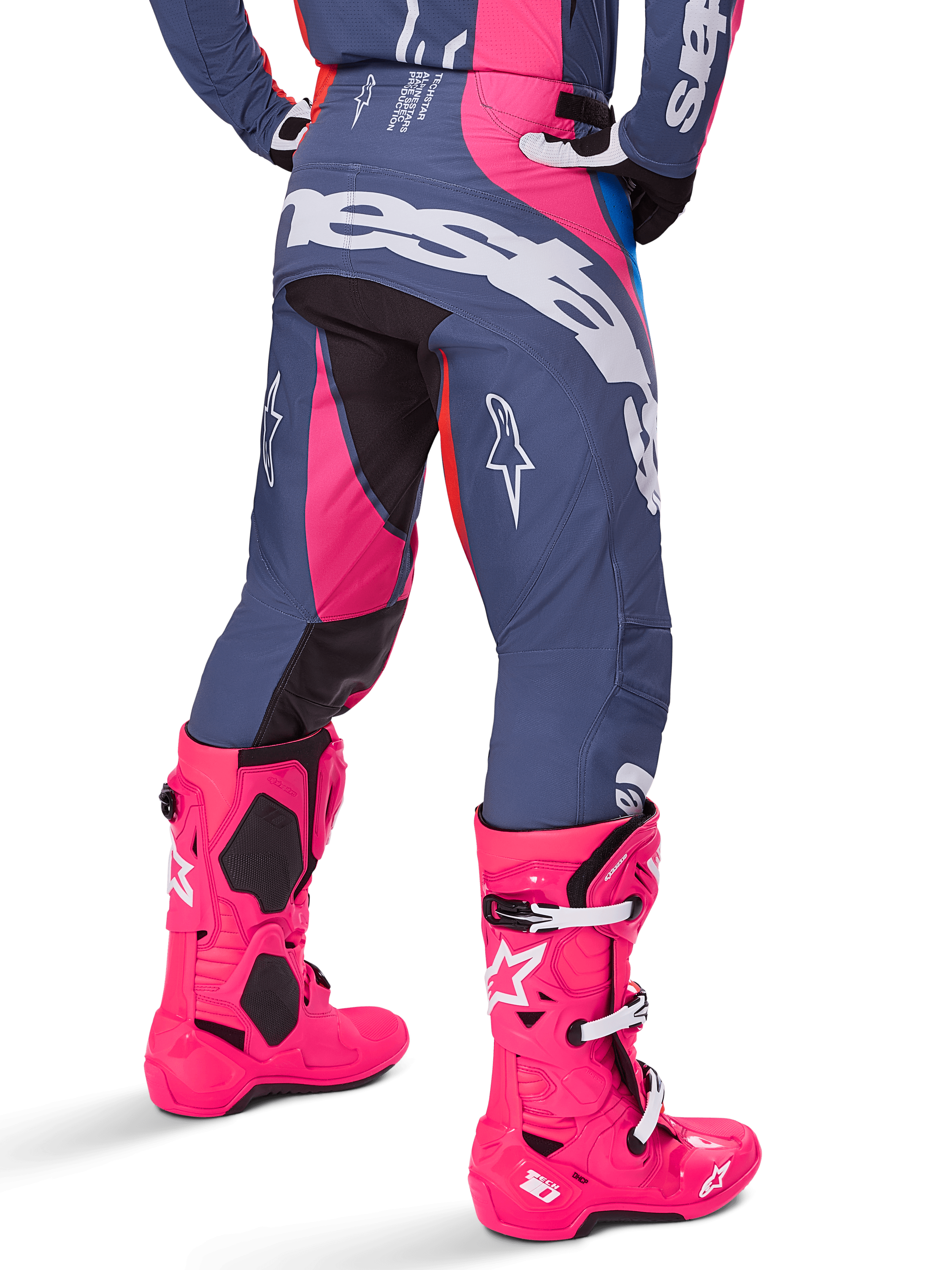 Alpinestars 2025 Techstar Dreem bukser, motocross-bukser, grå og lyserød multifarvet, set bagfra med stort hvidt Alpinestars-logo over bagen, båret med matchende panglyserøde Tech 10-støvler, slidstærkt off-road racingudstyr med forstærkede paneler