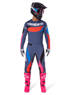 Alpinestars 2025 Techstar Dreem bukser, motocross-bukser, grå multicolor med lyserøde og blå detaljer, båret af en kører med en matchende teknisk trøje, sort hjelm og panglyserøde støvler, komplet high-performance off-road racingudstyr.