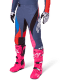 Alpinestars 2025 Techstar Dreem bukser, motocross-bukser, mørkegrå med blå, røde og pink paneler, hvid grafik, båret med skarpt pink støvler og sort-hvide handsker, markant design med høj synlighed