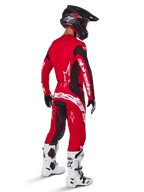 Alpinestars 2025 Techstar Dreem bukser, motocross-bukser, klar rød og sort, set bagfra på en kører i komplet racersæt med matchende rød trøje, sort hjelm og hvide støvler, med markant hvidt Alpinestars-branding og sorte stretch-paneler.