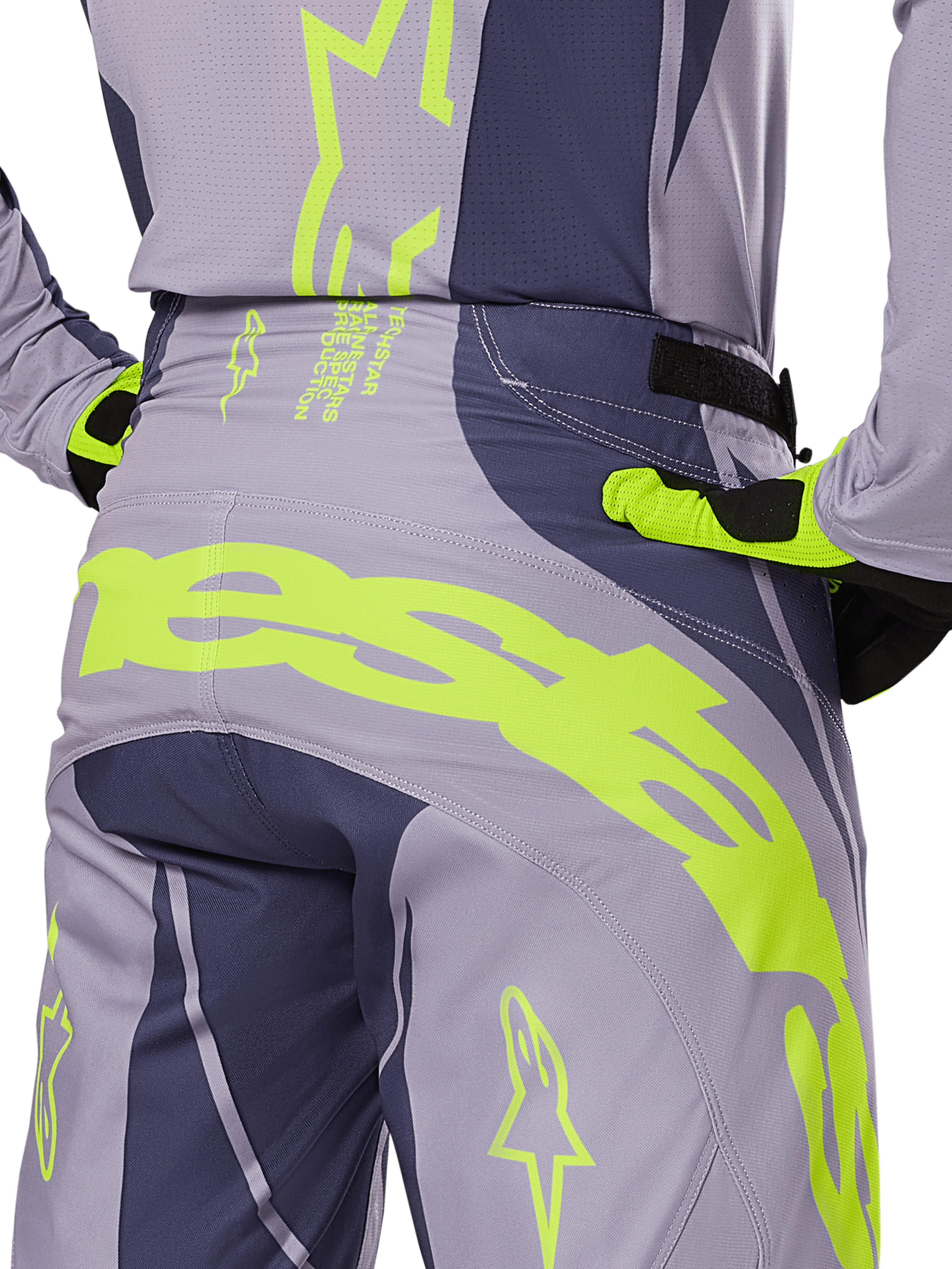 Alpinestars 2025 Techstar Dreem bukser, motocrossbukser, grå og mørkegrå med fluorescerende gule detaljer, set bagfra med tydelig Alpinestars-branding over bagstykket, vist med matchende trøje og handsker, designet til off-road racing.
