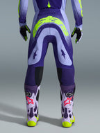 Alpinestars 2026 Supertech Scenz bukser, motocross-bukser, lilla og neon-gul, set bagfra med stort gult logo på bagdelen, båret med matchende trøje, handsker og beskyttelsesstøvler, atletisk pasform til professionel motocross-racing