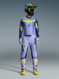 Alpinestars 2026 Supertech Scenz udstyrssæt, motocross raceroutfit, lys lilla og neongul-grøn, komplet beskyttelsesudstyr inklusive sort hjelm med lilla detaljer, jersey med markant neongul branding, matchende bukser med stjernegrafik og koordinerede støvler med pink detaljer.
