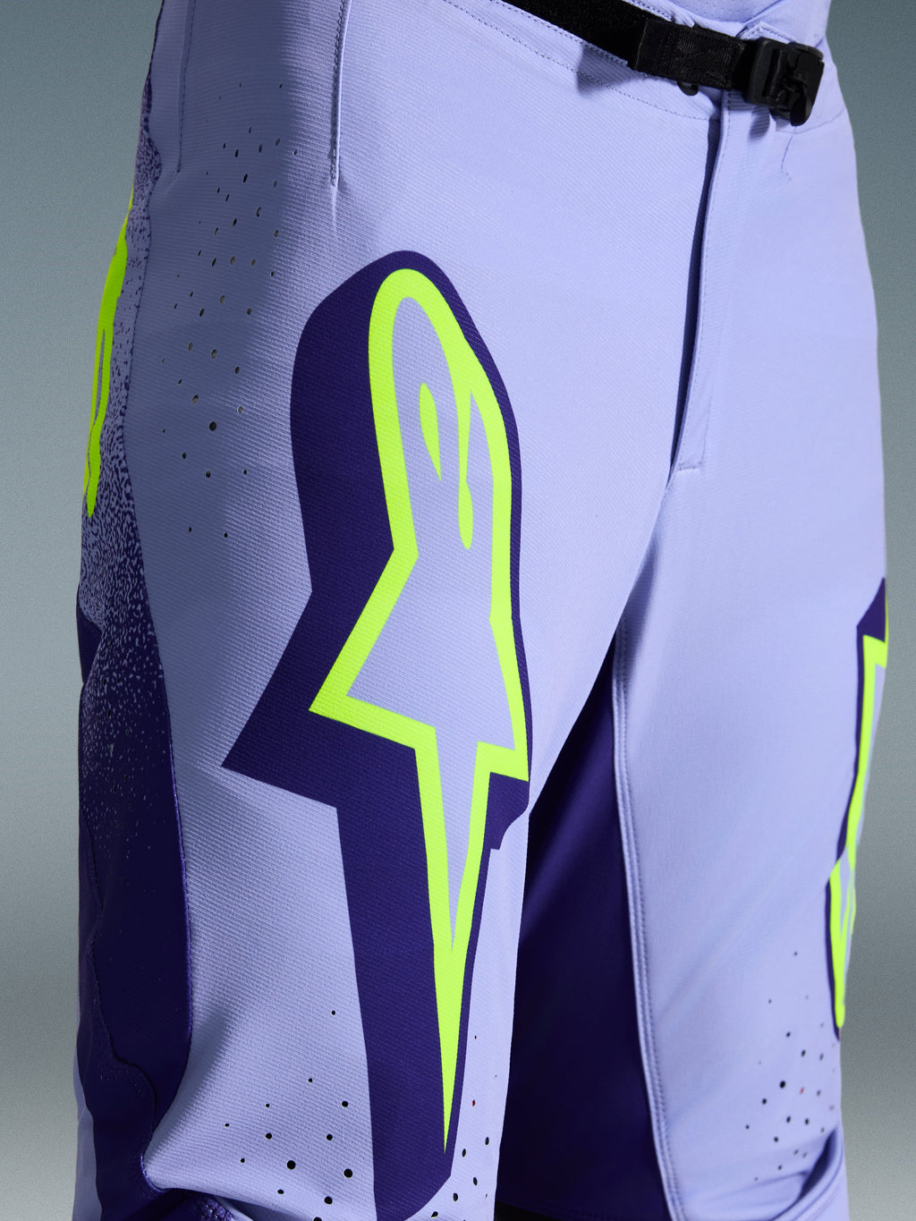 Alpinestars 2026 Supertech Scenz bukser, motocrossbukser, lilla og fluoriserende gul, nærbillede med stort gult logo på låret, laserskårne perforeringer til ventilation og magnetisk taljespænde, off-road udstyr med atletisk pasform