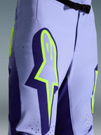 Alpinestars 2026 Supertech Scenz bukser, motocrossbukser, lilla og fluoriserende gul, nærbillede med stort gult logo på låret, laserskårne perforeringer til ventilation og magnetisk taljespænde, off-road udstyr med atletisk pasform
