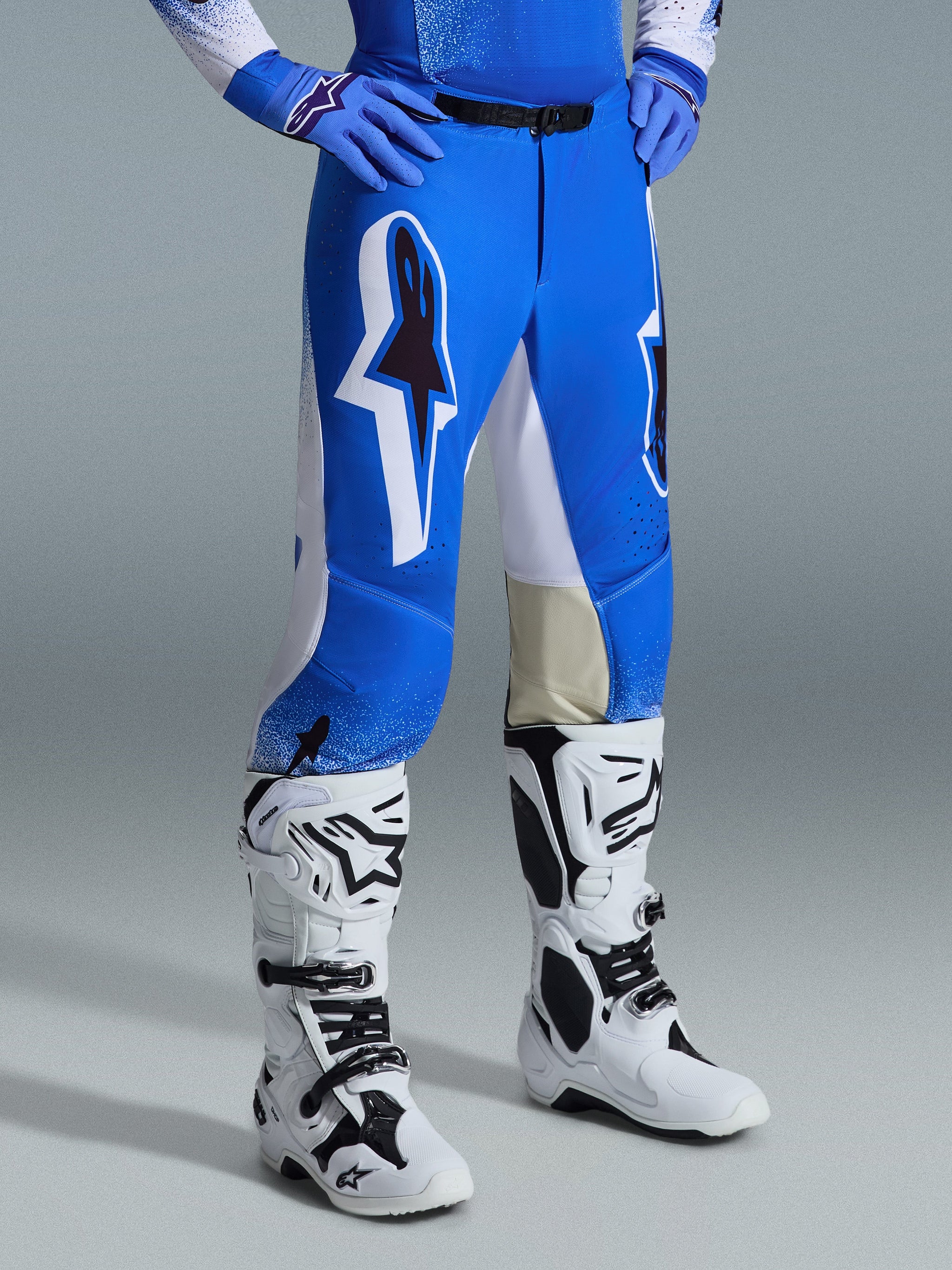 Alpinestars 2026 Supertech Scenz Pants, Motocross Pants, Ucla Blue and White, worn with white and black boots and blue gloves, featuring large graphic logos on the thighs and white panels, athletic fit designed for competitive dirt bike riding