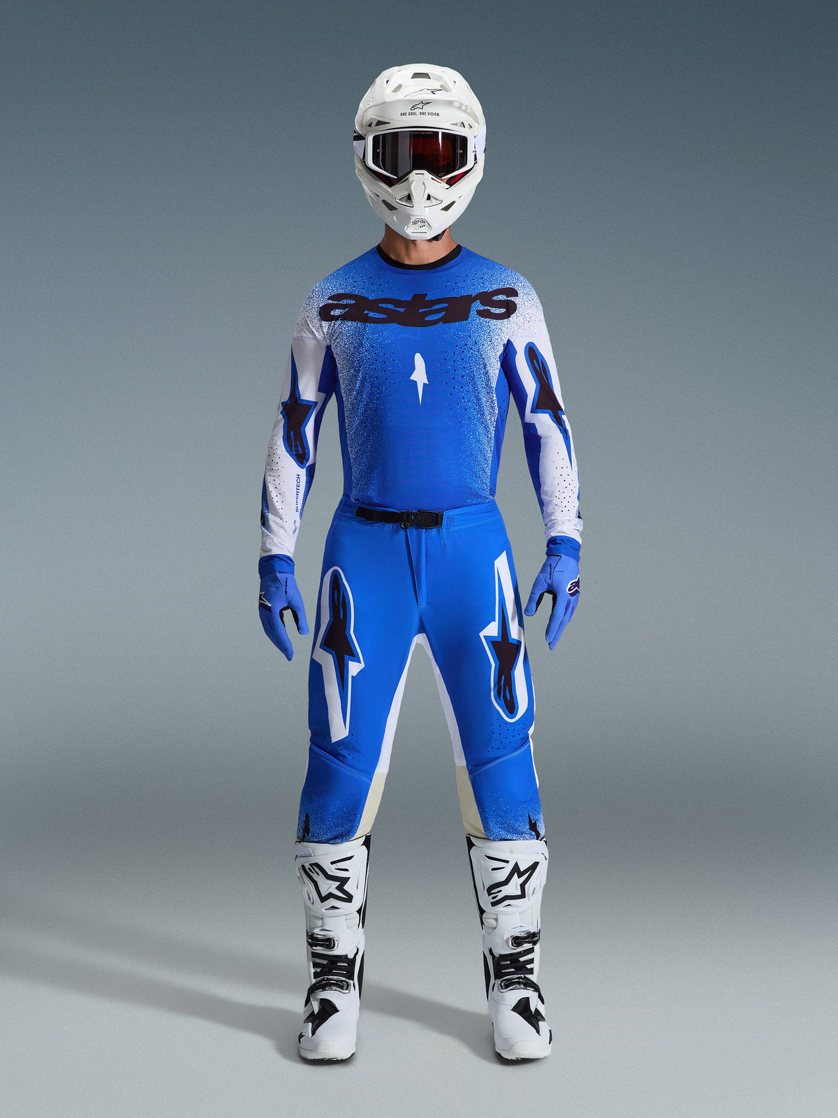 Alpinestars 2026 Supertech Scenz Gear Sæt, motocross-racingudstyr, Ucla Blue og hvid, komplet racersæt med blå jersey med sort 'astars'-logo, matchende bukser med stjernemønster, hvid hjelm med mørke goggles, blå handsker og hvide støvler med sorte detaljer