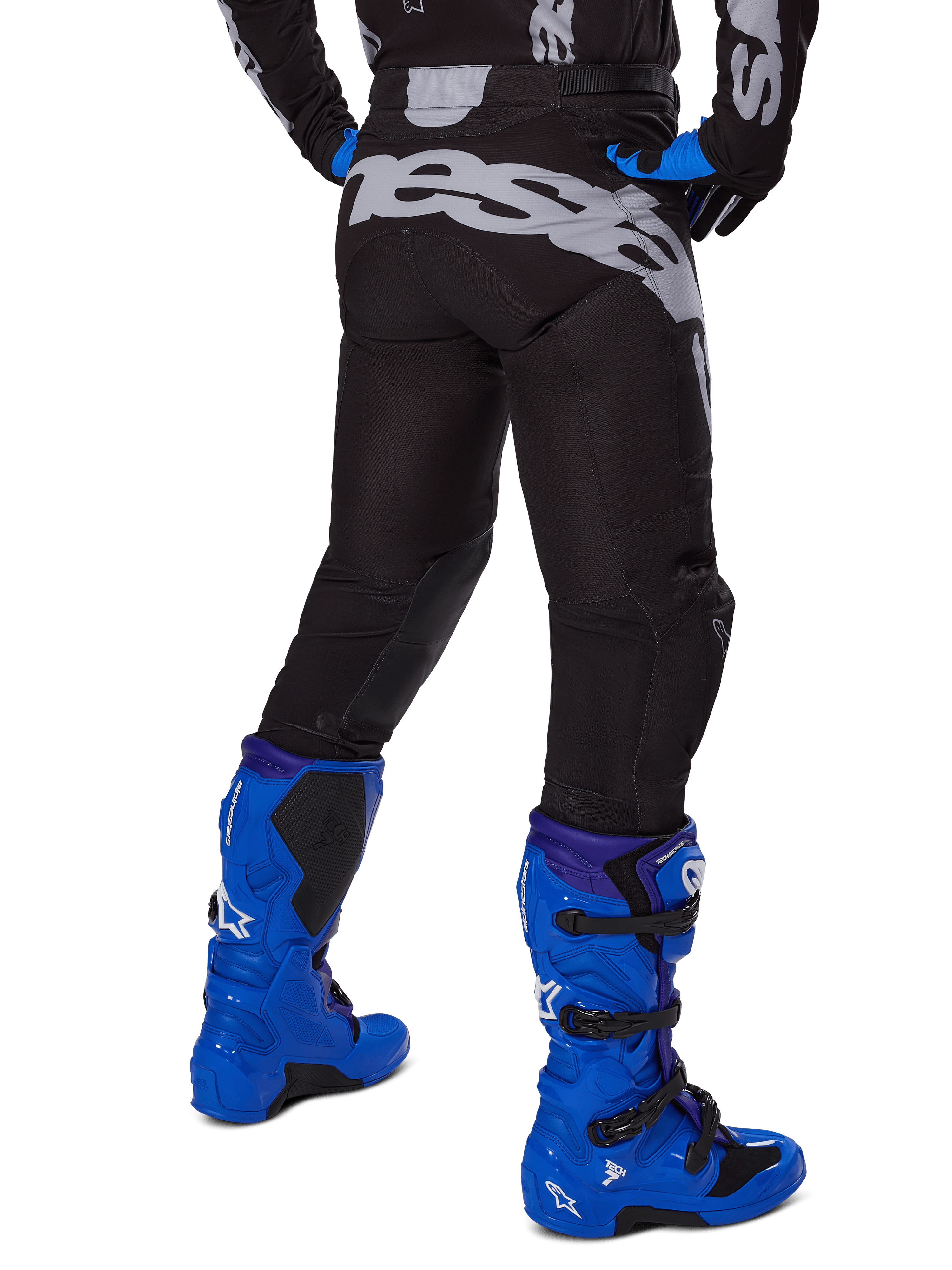 Alpinestars 2025 Racer Graphite Pants, Motocross Pants, Black and Gray, rear view with large gray branding on the seat, worn with bright blue motocross boots and black and blue jersey, durable off-road racing gear