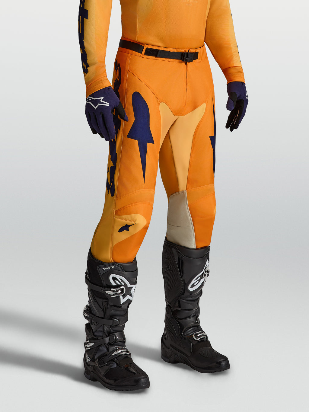 Alpinestars Racer Amber Bukser, orange og mørkeblå motocrossbukser med strækindsatser og ergonomisk forbuet benkonstruktion.
