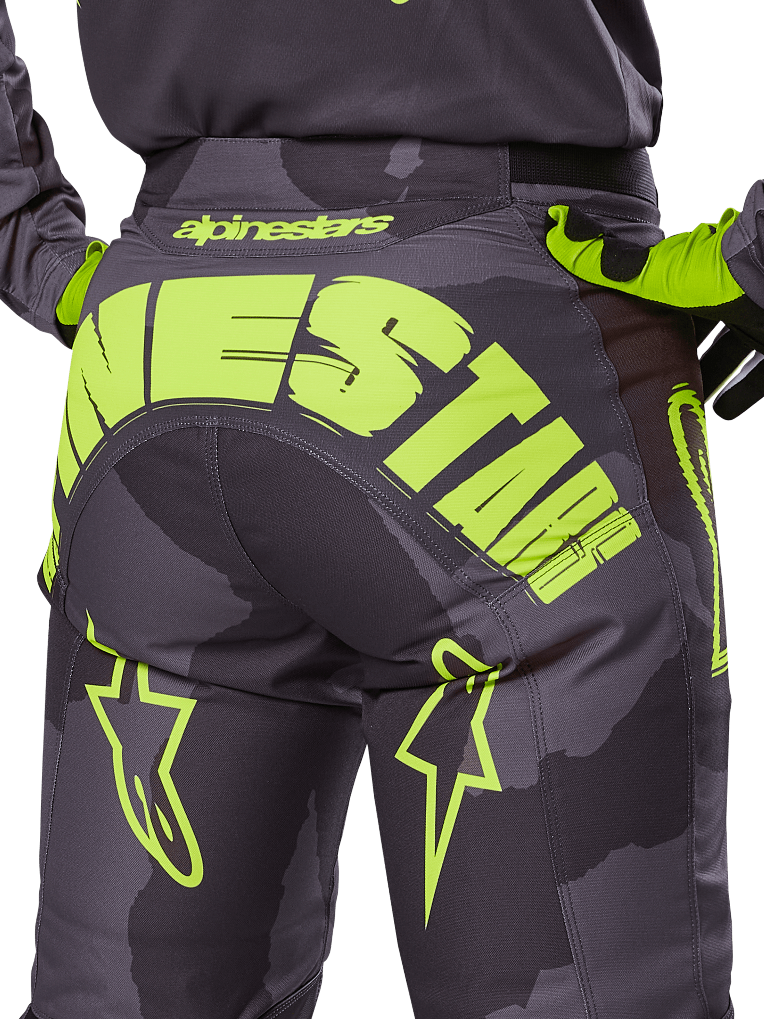 Alpinestars 2025 Racer Hollow-bukser, motocross-bukser, mørk camo og neon-gul, med et stort gult Alpinestars-logo hen over bagdelen, taktisk camouflagemønster med klare gule detaljer og slidstærk konstruktion til off-road racing.