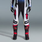 Alpinestars 2026 Techstar Knif-udstyrssæt, motocross-udstyr, sorte og hvide bukser med store røde stjernelogoer, båret med sorte og røde racingstøvler og sorte handsker, professionel atletisk pasform til off-road-performance